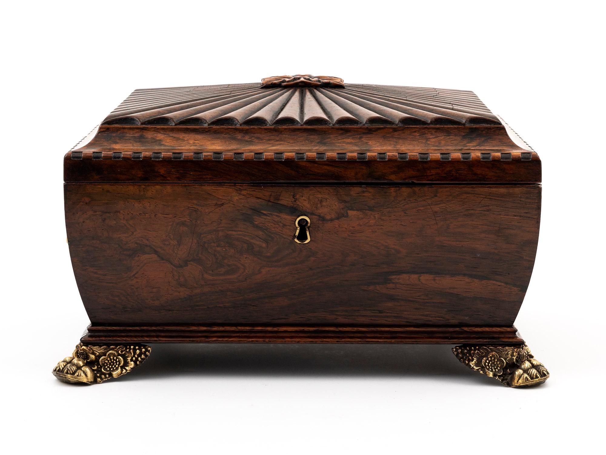 Introducing a truly magnificent Antique Sarcophagus-shaped Rosewood Jewellery Box, an extraordinary masterpiece that will captivate you with its exceptional beauty and craftsmanship.

This remarkable box boasts a beautifully carved fan design on