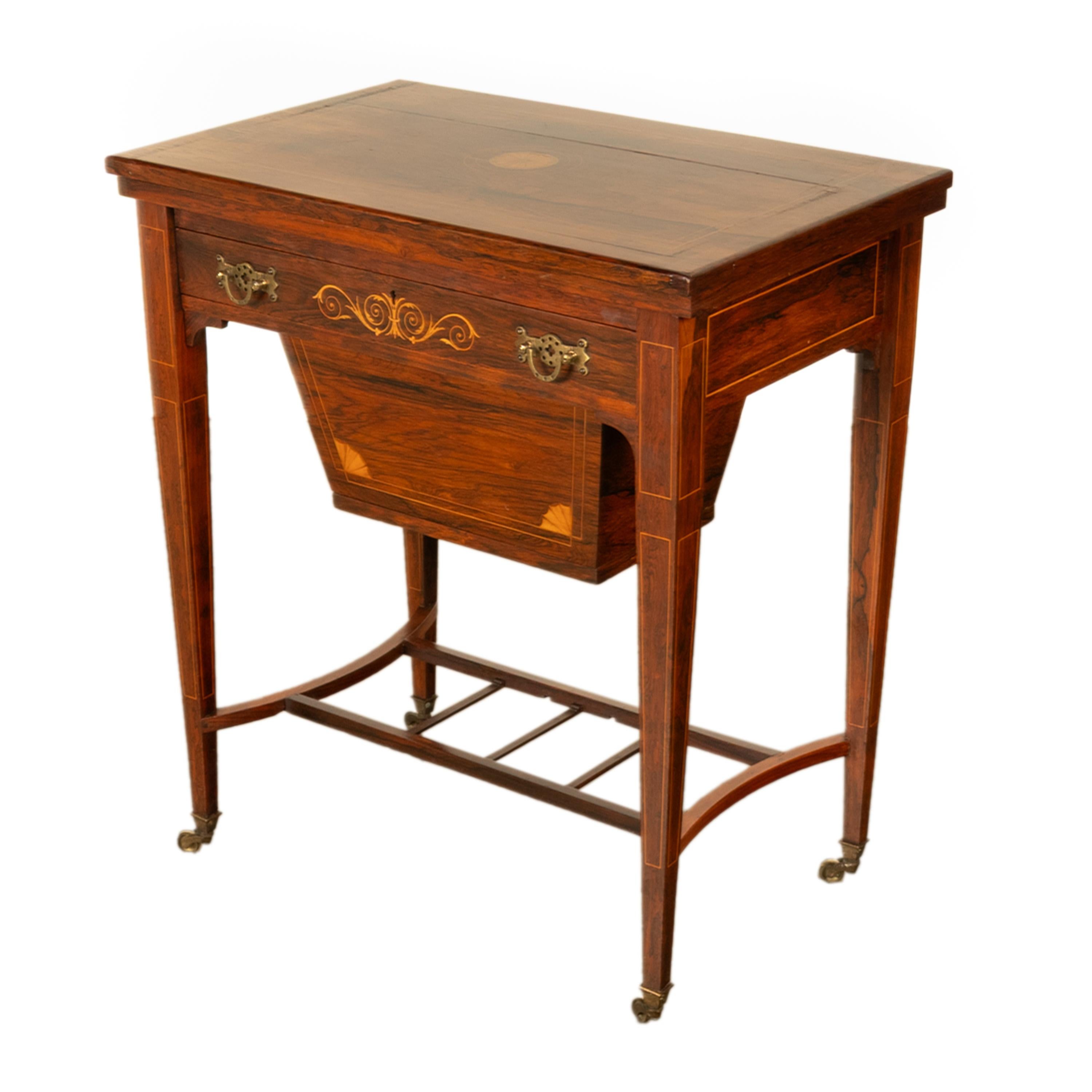 A very fine antique Regency Revival marquetry inlaid rosewood combination games and sewing table, circa 1890.
The finely grain figured rosewood table having a hinged top inlaid with satinwood stringing and a circular patera, the table opens and