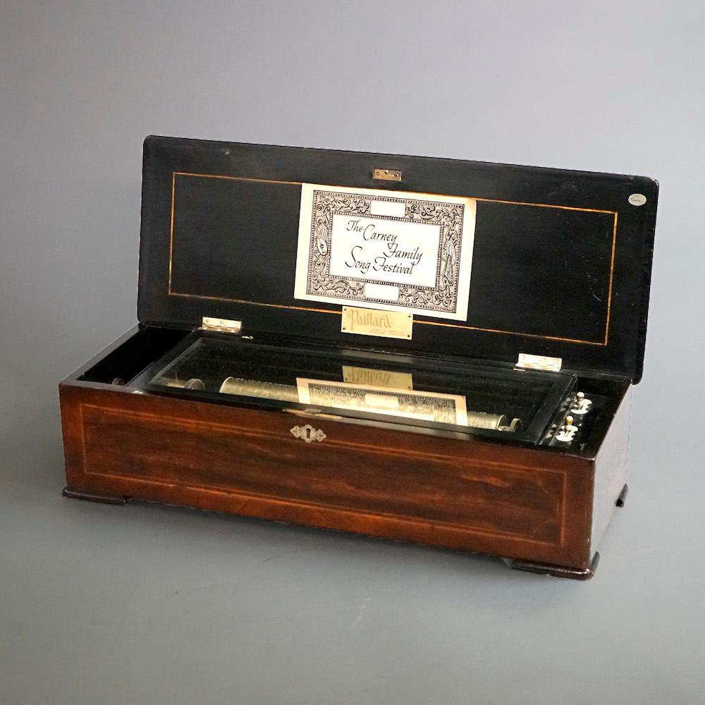 An antique Swiss music box offers rosewood case with crossbanding and floral marquetry inlay, c1890

Measures- 6.5'' H x 25'' W x 9'' D.