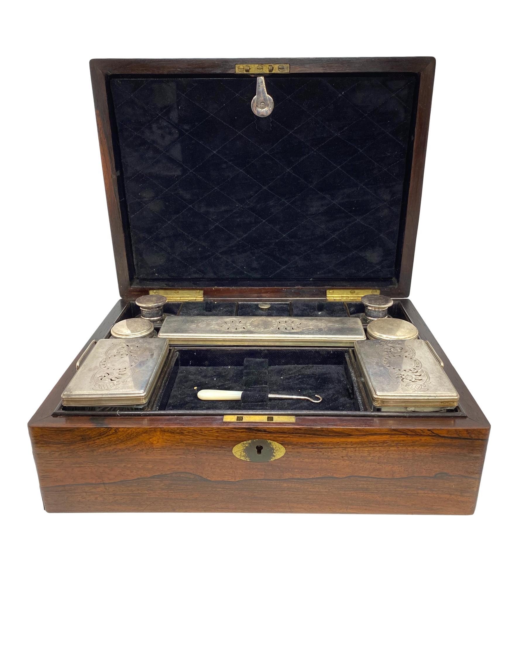 Antique rosewood travel box, with inlaid brass, the fitted interior complete with all items, including brushes, bottles, sewing items, etc., English, circa 1870.
