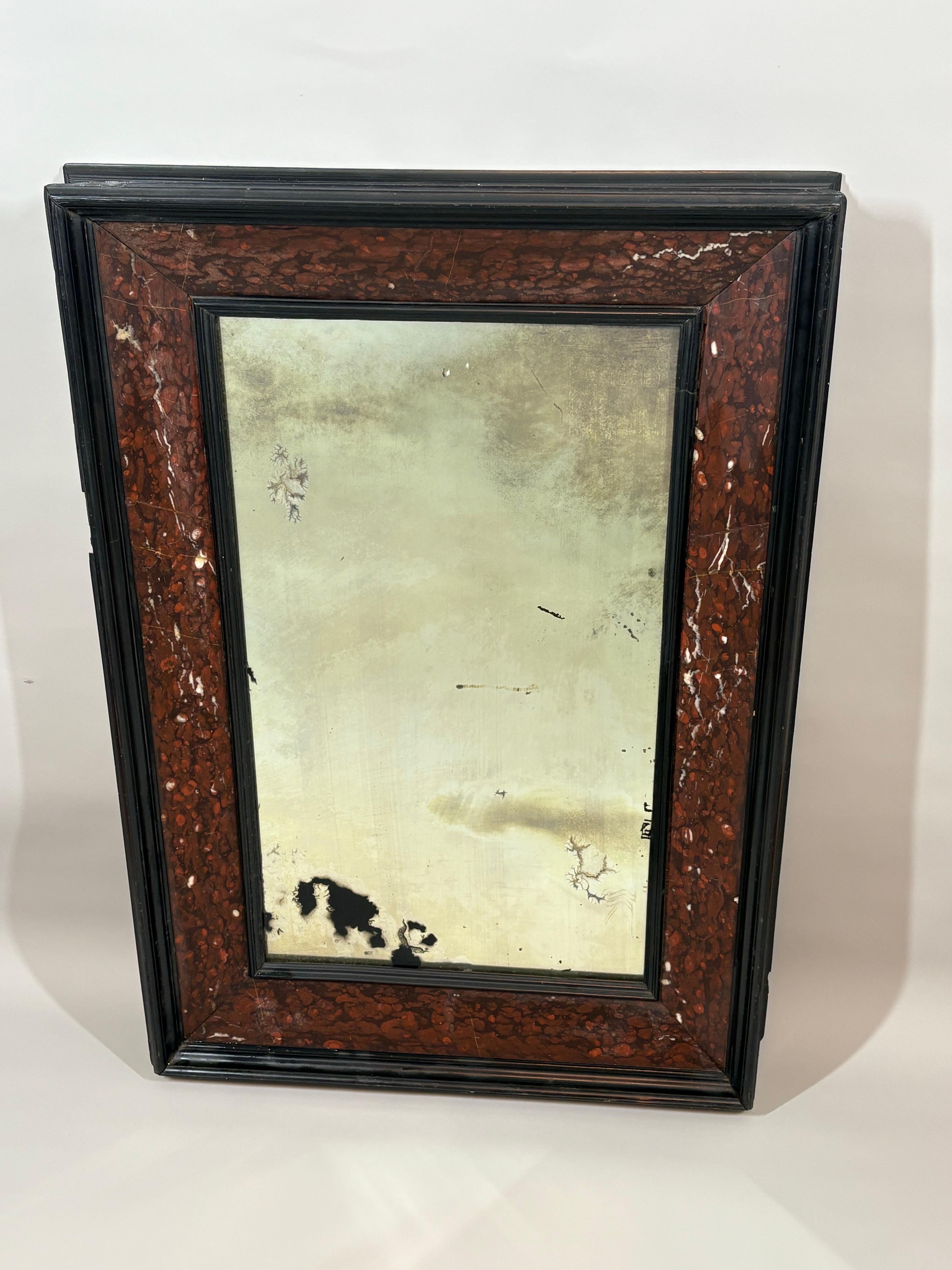 A handsome 19th century, 17th century Dutch style ebonized wood mirror with thick rough marble veneer on the frame and original leaded glass mirror.  Probably Dutch, circa 1860. 