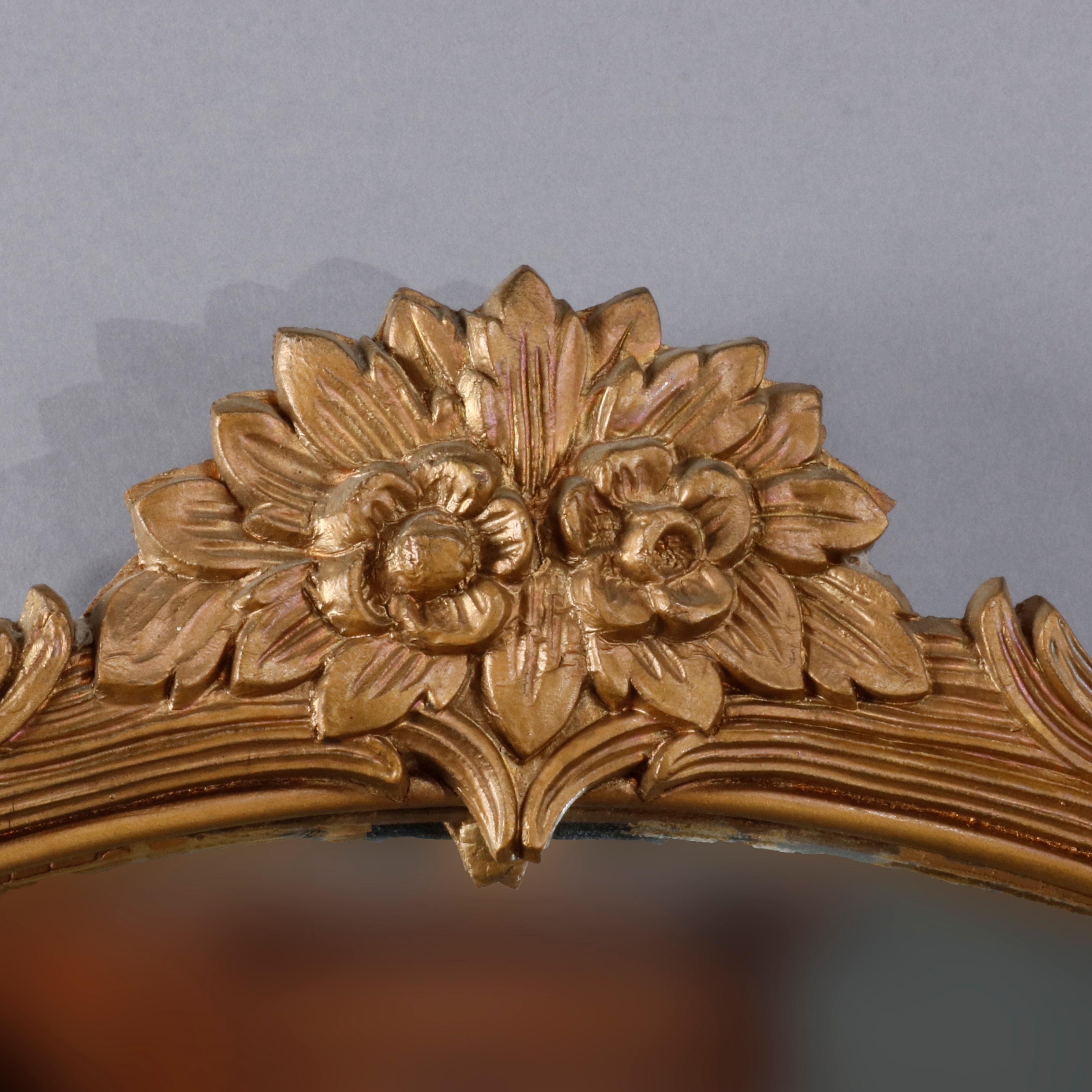 An antique Art Deco wall mirror offers giltwood frame with floral crest surmounting reeded foliate form round frame, 20th century

Measures - 32.5