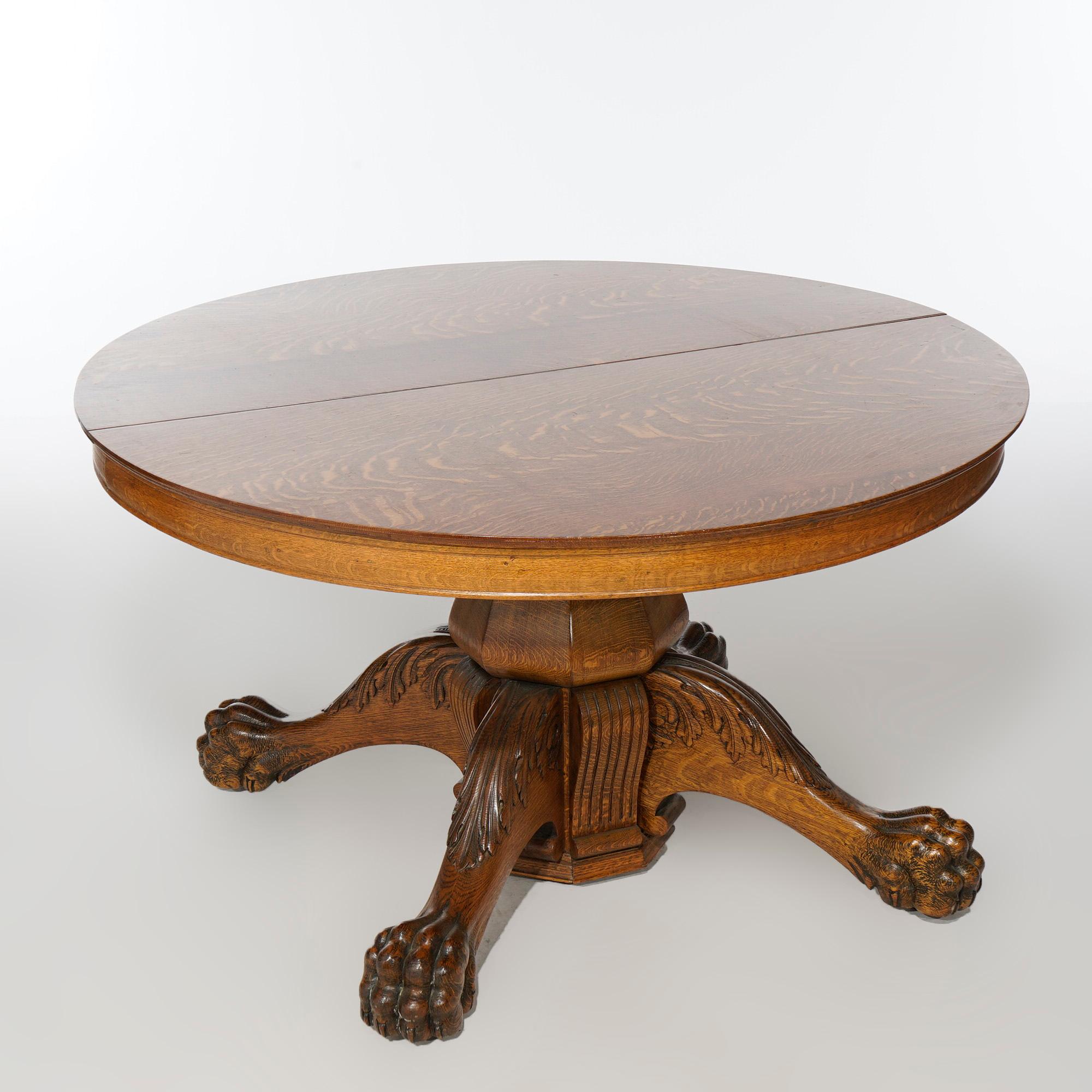 An antique extension dining table offers oak construction with round top over urn-form pedestal raised on cabriole legs with acanthus knees and carved paw feet, accepts three leaves, c1910

Measures- Without leaves 29.25''H x 54.5''W x