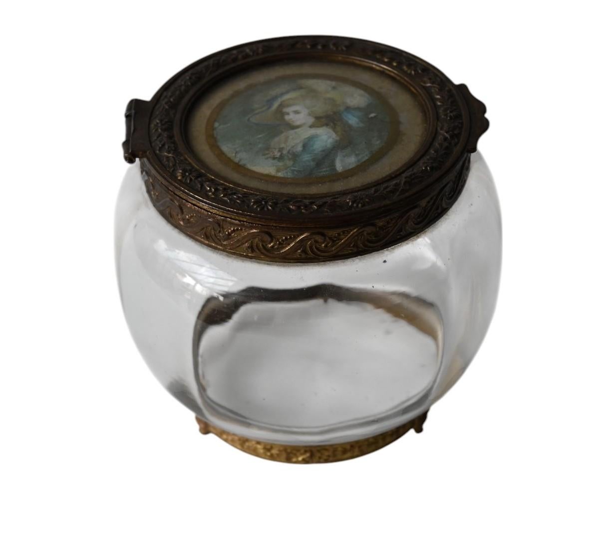 An antique round glass box with in the lid a painted miniature from a noble lady
Late 19th century
The inside of the lid has a mirror
The glass box have a frame from gilded brass
Diameter box is 10 cm