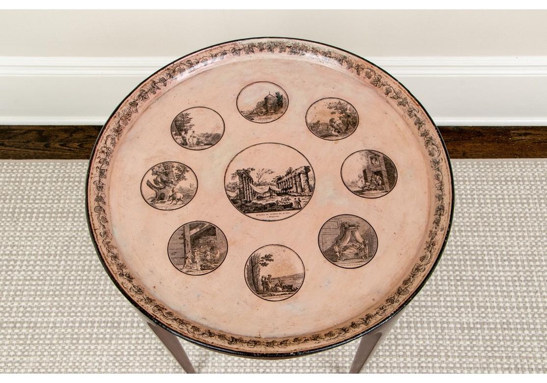 An antique pale salmon round tray in a custom wood stand with fine form which acts as a decorative and very interesting tray table. The tray has artwork scenes of a rural, pastoral and neoclassical themes.
Condition is very good with expected age