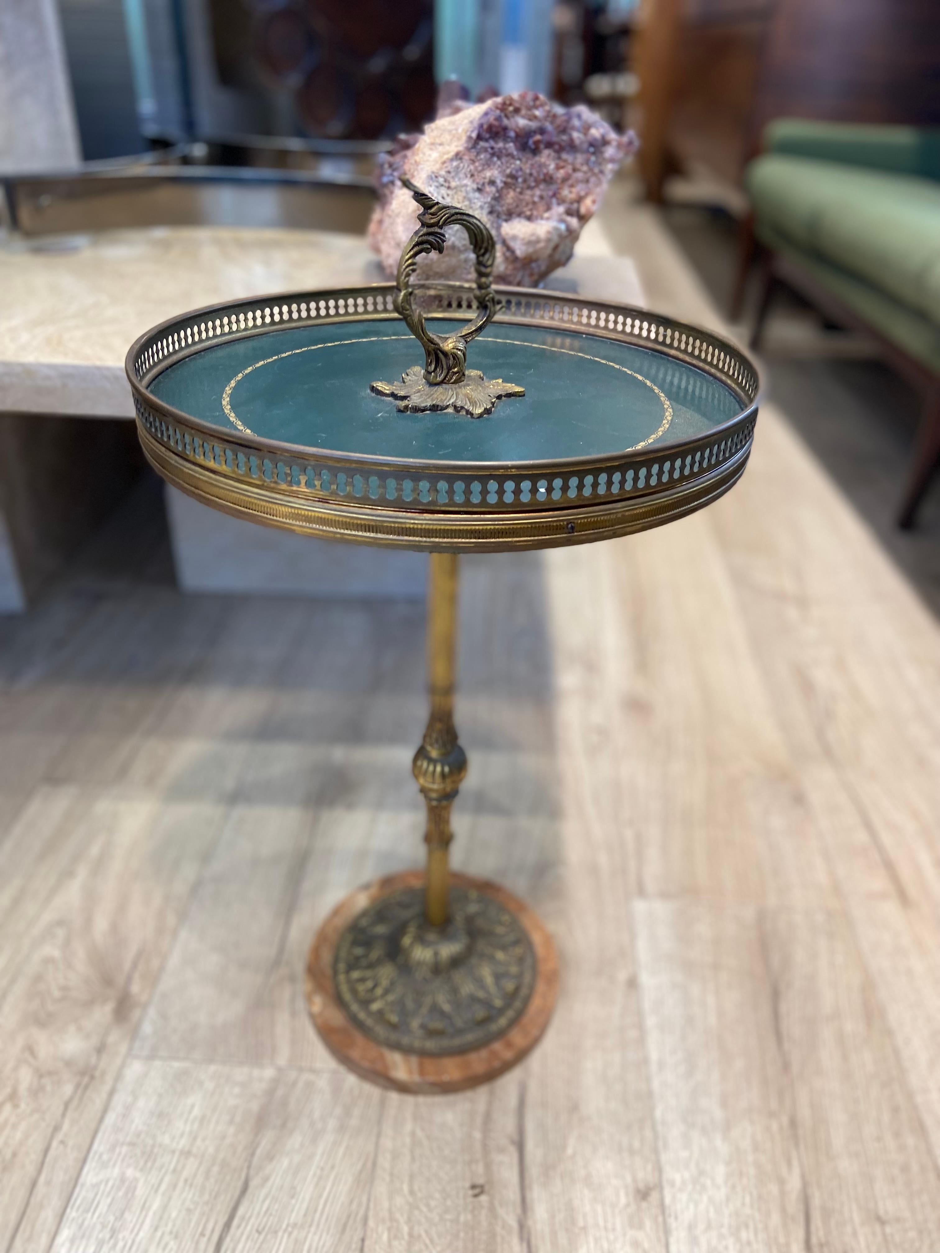 Un antico cavalletto rotondo, dal design splendido, con un piano in ottone che poggia su una splendida base in marmo. 

La combinazione di ottone e marmo conferisce a questo pezzo un fascino elegante e senza tempo. 

Il suo design versatile si
