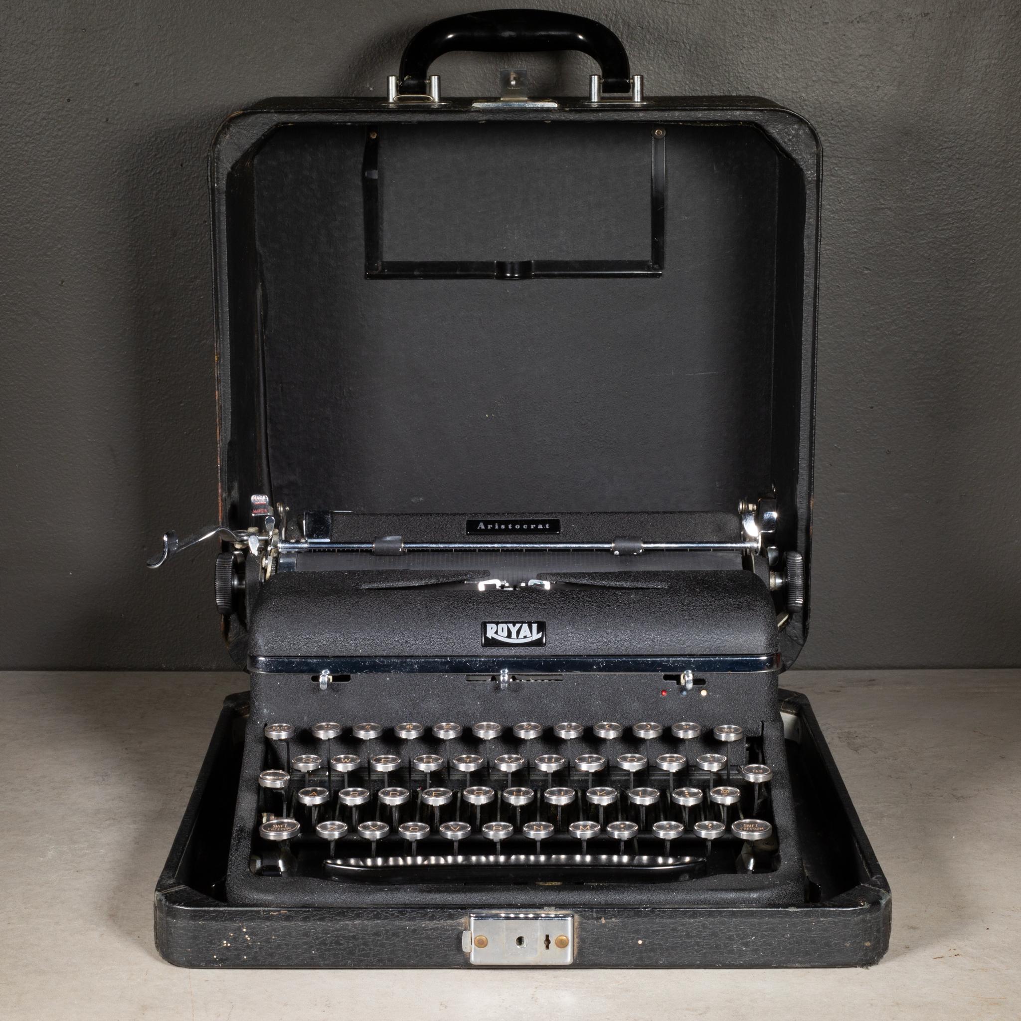 ÜBER

Eine antike Royal Aristocrat-Schreibmaschine mit schwarzer, gewellter Oberfläche und Originalkoffer. Die Tasten sind aus Nickel und Glas mit goldenen Buchstaben auf schwarzem Hintergrund. Das Gehäuse hat einen Bakelitgriff. Seriennummer: