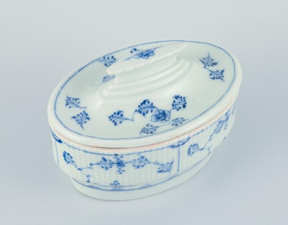 Antique Royal Copenhagen Blue Fluted butter dish.
Rare butter dish from around 1820.
Marked with three blue waves. Model number 7.
In very good condition with a minor insignificant chip on the underside of the lid's top.
Dimensions: L 13.5 cm x W