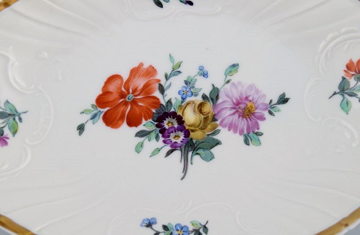 Antique Royal Copenhagen Saxon bowl / dish in porcelain with hand-painted flowers and gold edge. 
Early 20th century.
Measures: 23 x 15.5 x 3.5 cm.
In excellent condition.
Juliane Marie stamp.