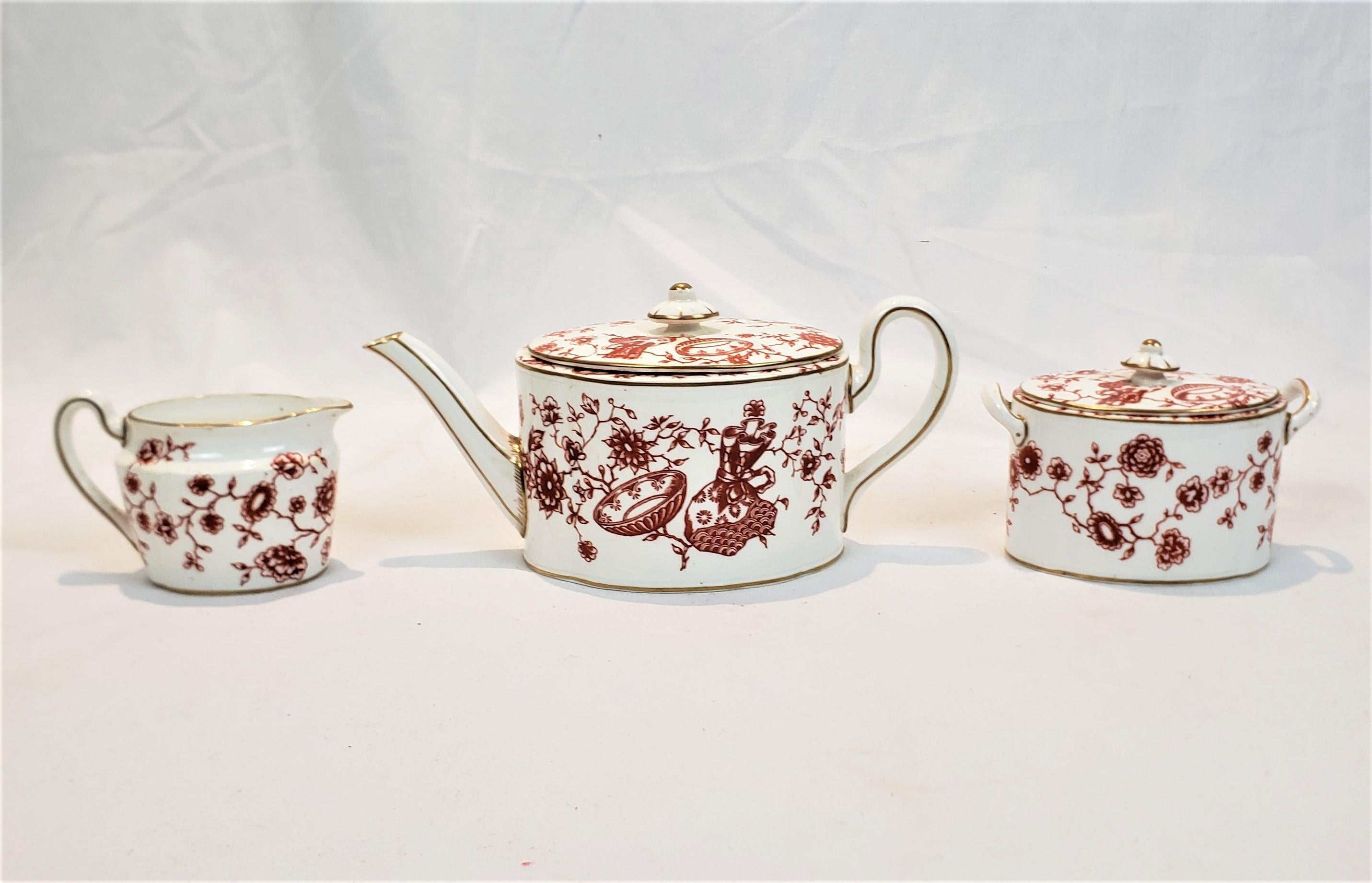 This teapot and cream and sugar set were made by the well known Royal Crown Derby maker of England and dates to approximately 1850 and done in the period Chinoiserie style. The set is composed of porcelain with a small, possibly two cup teapot and a