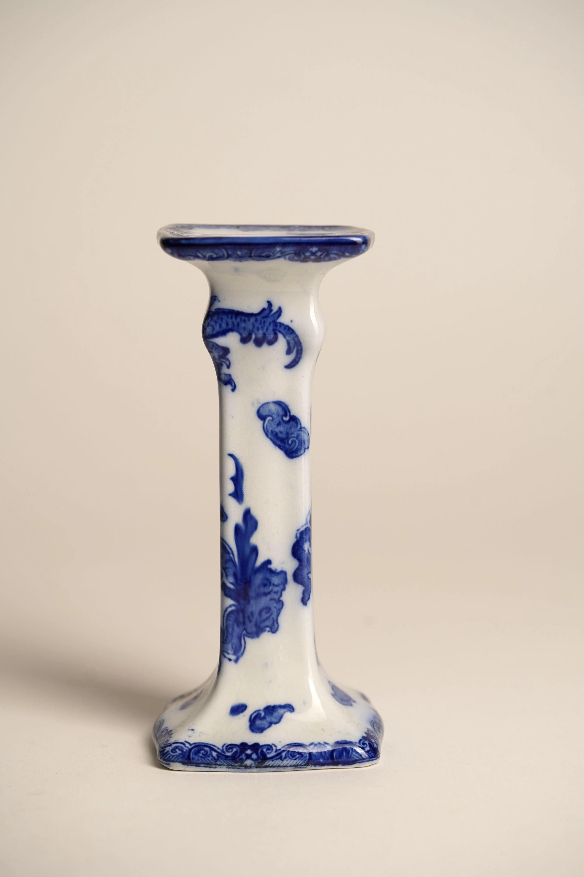 Crafted in fine porcelain by Royal Doulton and marked accordingly, this pair of hand-painted candle stands features the rare and dramatic Oyama pattern—an homage to East Asian design, rich in symbolism and artistry. Vivid cobalt dragons sweep across