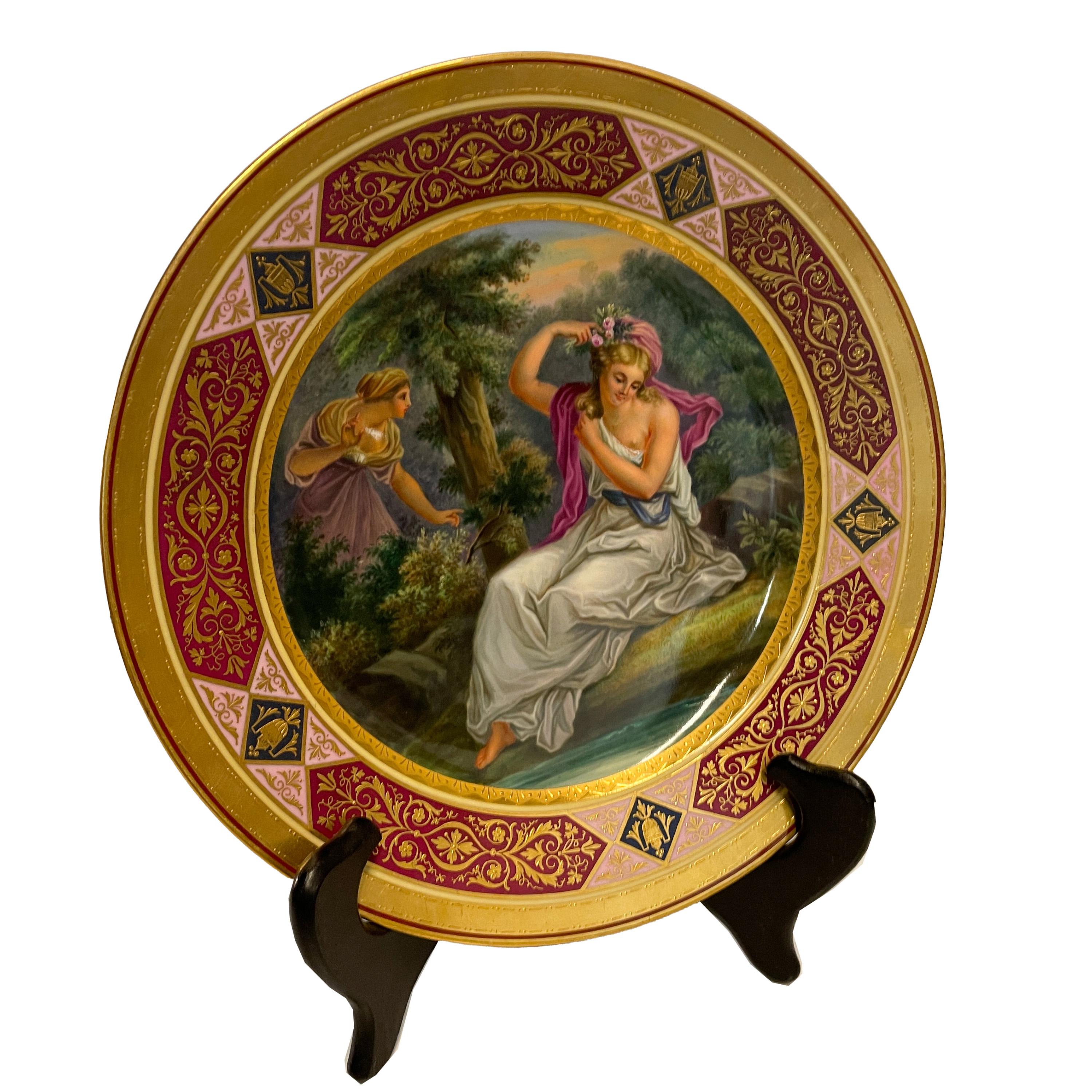 Assiette de cabinet en porcelaine peinte à la main et dorée de la Royal Vienna, vers 1890.
L'assiette est très finement décorée d'une scène centrale peinte à la main représentant la déesse Daphné assise près d'une vapeur dans un cadre bucolique,