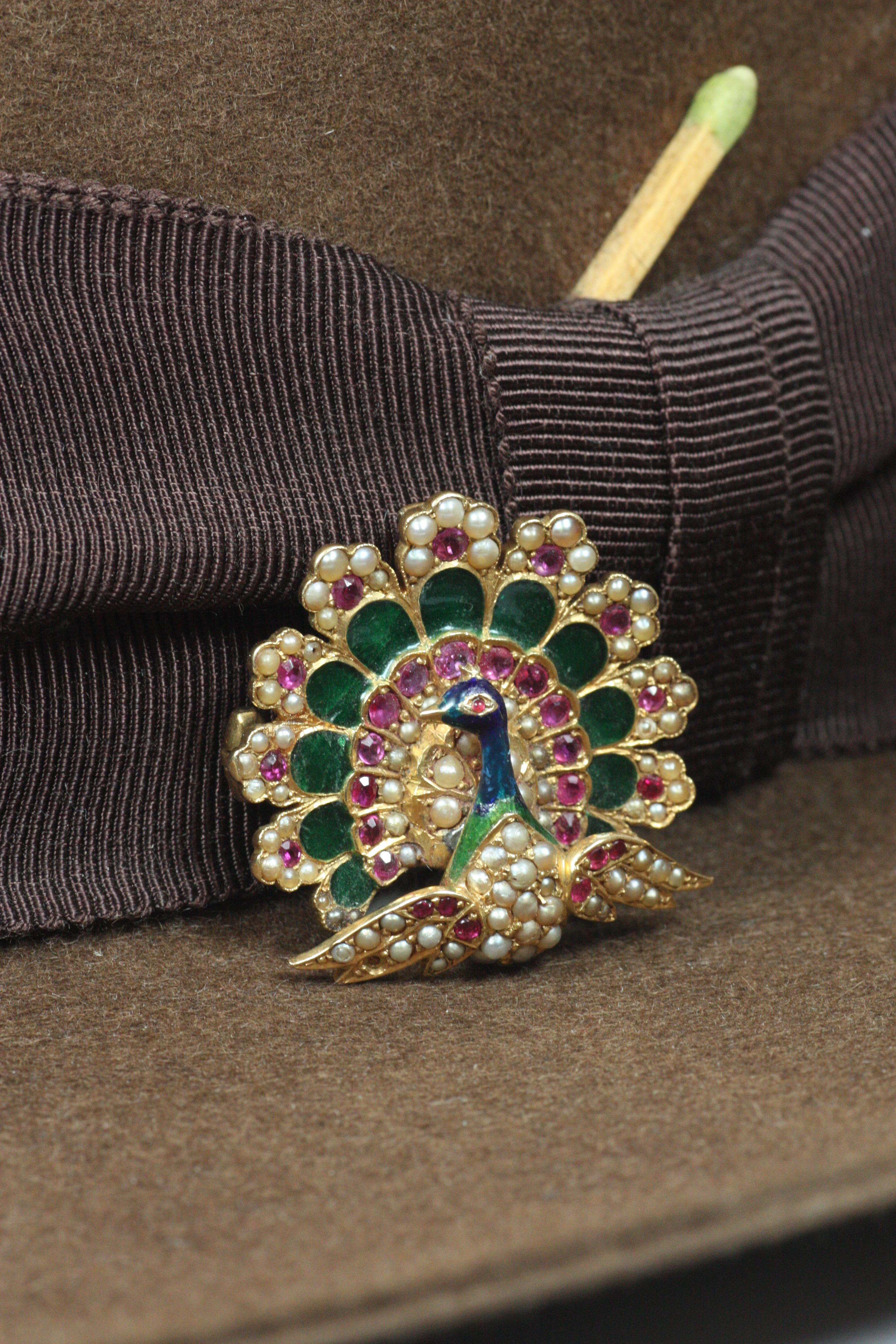 This antique peacock brooch, signed R.B. & Co. and circa 1900, is a beautiful piece showcasing fine plique-à-jour enameling, en ronde bosse enamel, rubies, and pearls in 18K (“18C”) yellow gold. Includes an articulating loop to hang it on a chain