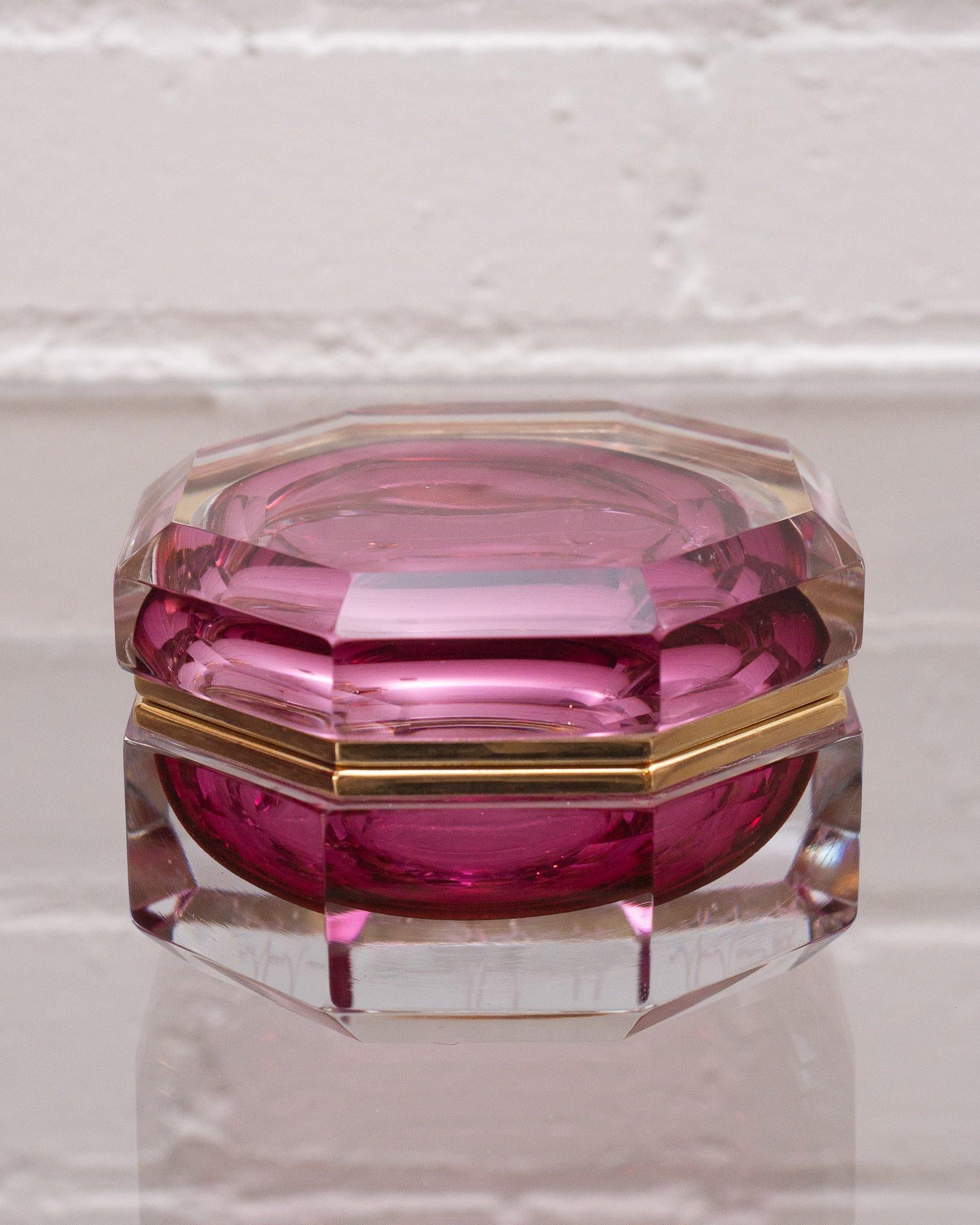 This antique ruby and clear crystal and bronze box makes a statement in any space. An early 1900s production, this piece transitions from modern to Classic interiors seamlessly with its sophisticated shape and light catching quality.
