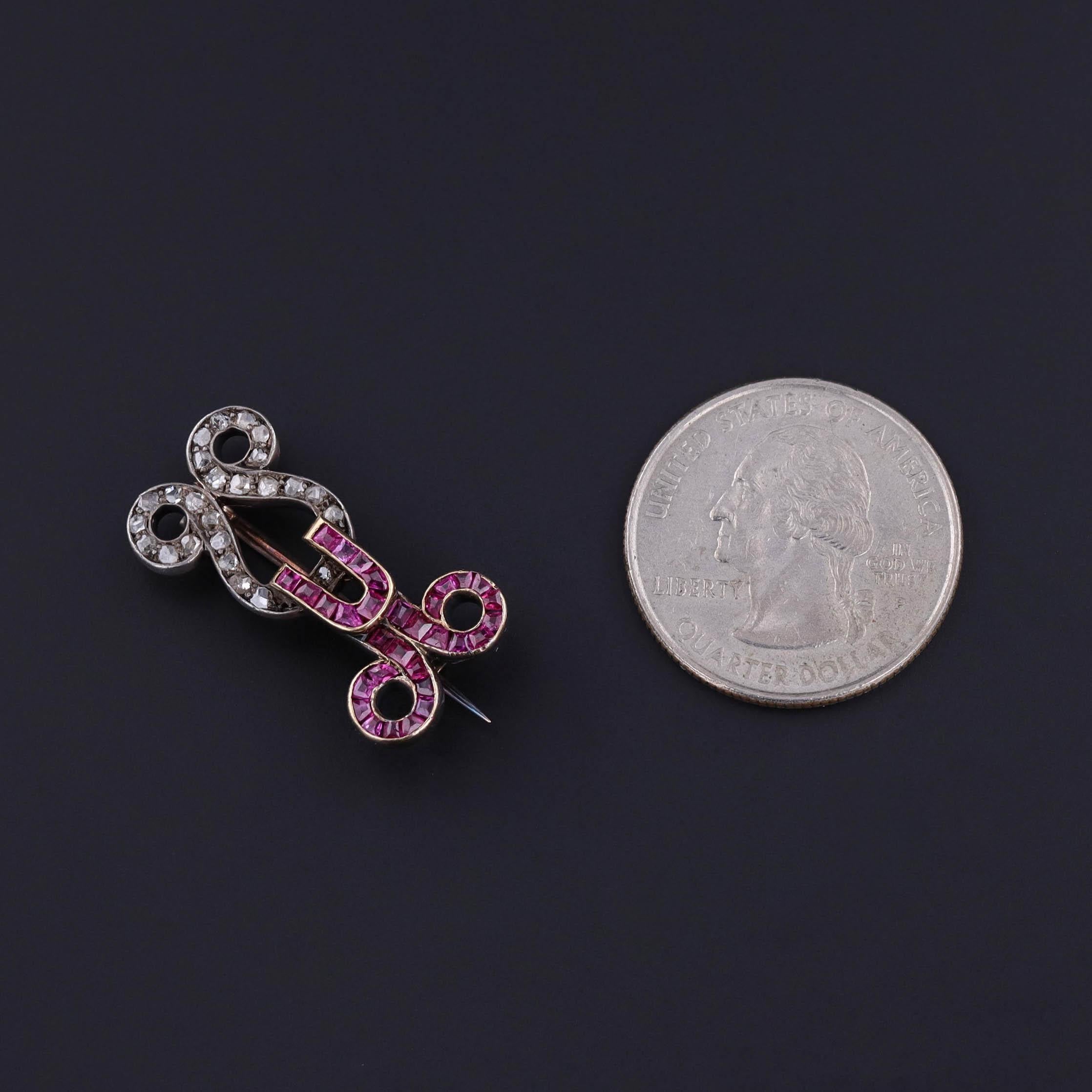 Antique Ruby and Diamond Brooch: This antique brooch (circa 1870-1880) features a 'hook' of rubies and a 'latch' of diamonds set in 12ct gold.

The hook and latch piece measures 0.55 inches by 1.1 inch wide and weighs 5.4 grams. It is in great