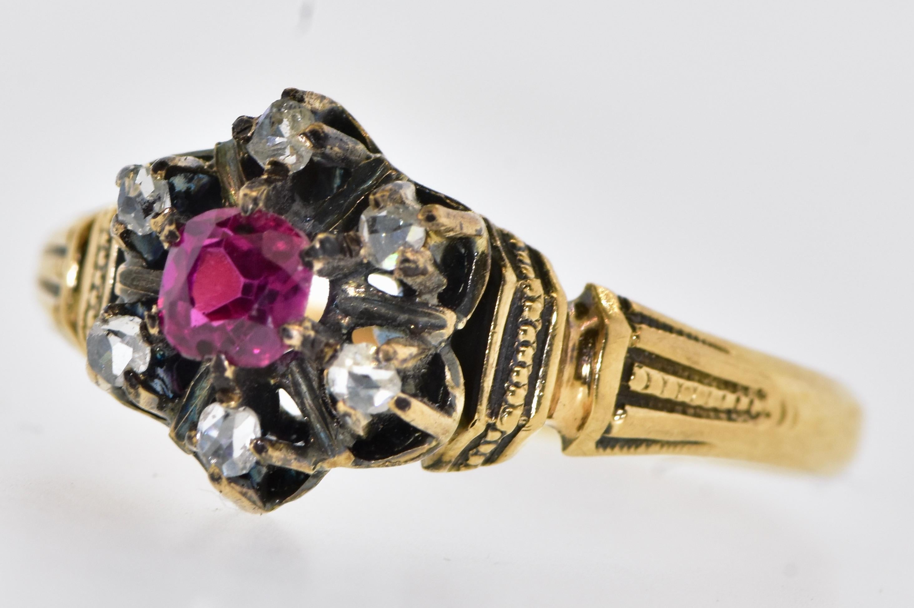 Antiker Ring mit Diamanten und Rubinen.  Dieses wahrscheinlich in Amerika gefertigte kleine Meisterwerk besteht aus 6 kleinen, in Zacken gefassten Diamanten im Rosenschliff, die einen natürlichen, leuchtend roten Rubin umschließen, der