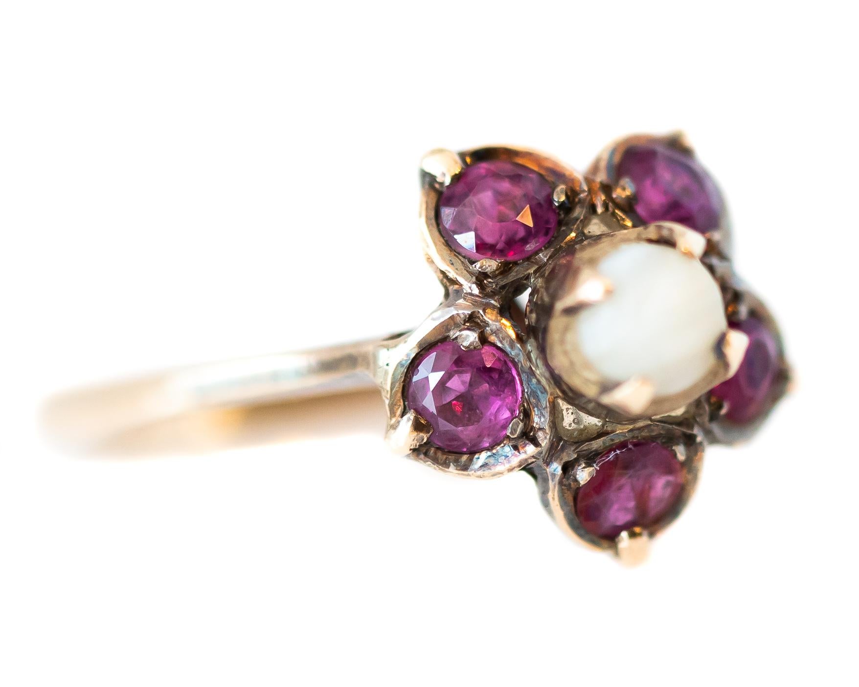 Antique Circa 1880 Ruby and Pearl Floral Ring - 18 Karat Yellow Gold, Rubies, Pearl

Features:
Floral Design
Round Pearl Center
5 pinkish red Round Ruby-set petals
18 Karat Yellow Gold, with a light patina
Elevated setting with Open Back
Prong set