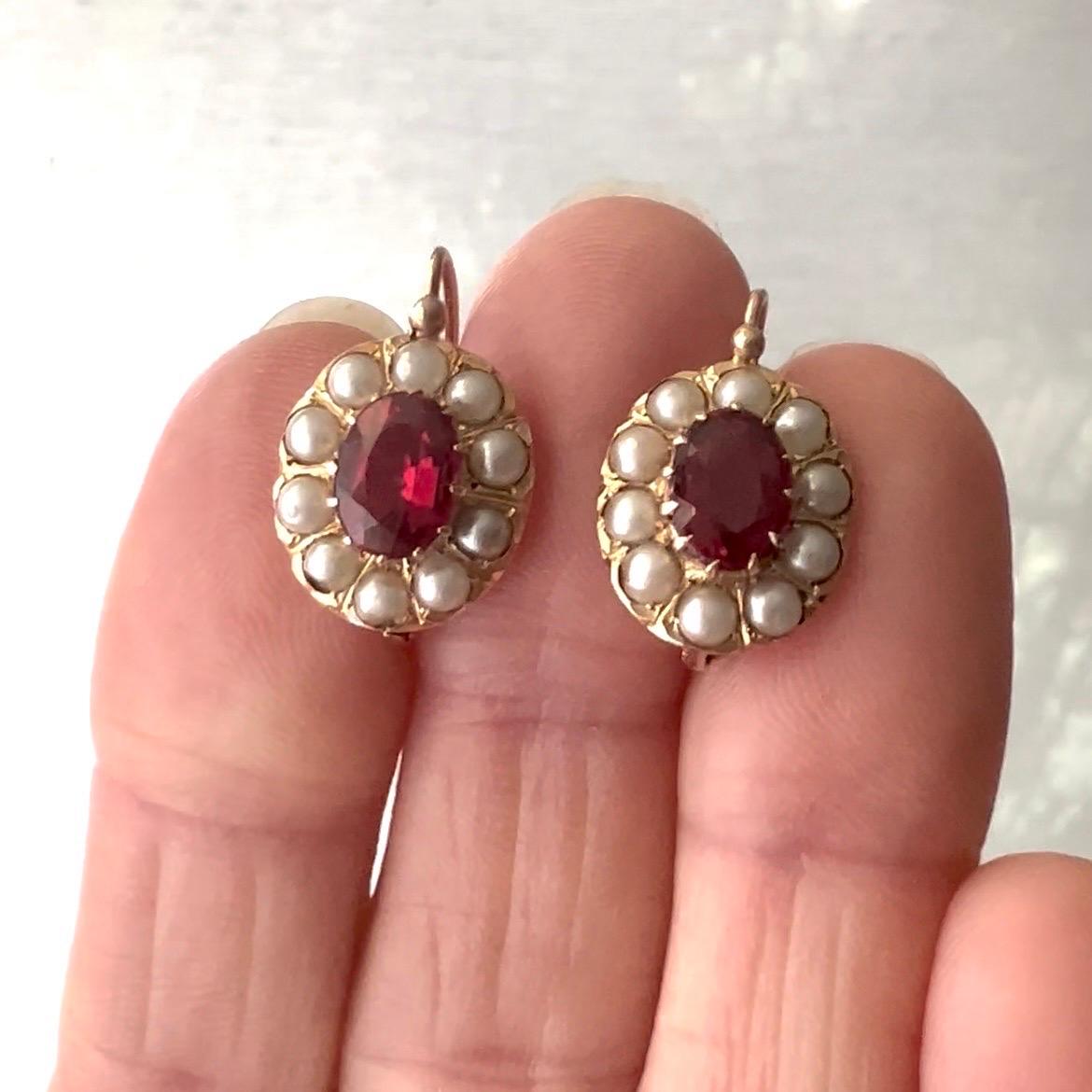 These antique ruby and seed pearl earrings are perfectly accented with its delicate gold openwork frame. The lovely translucent pinkish rubies and bright pearls make the earrings very attractive.

A beautiful 14 karat gold openwork frame adorns
