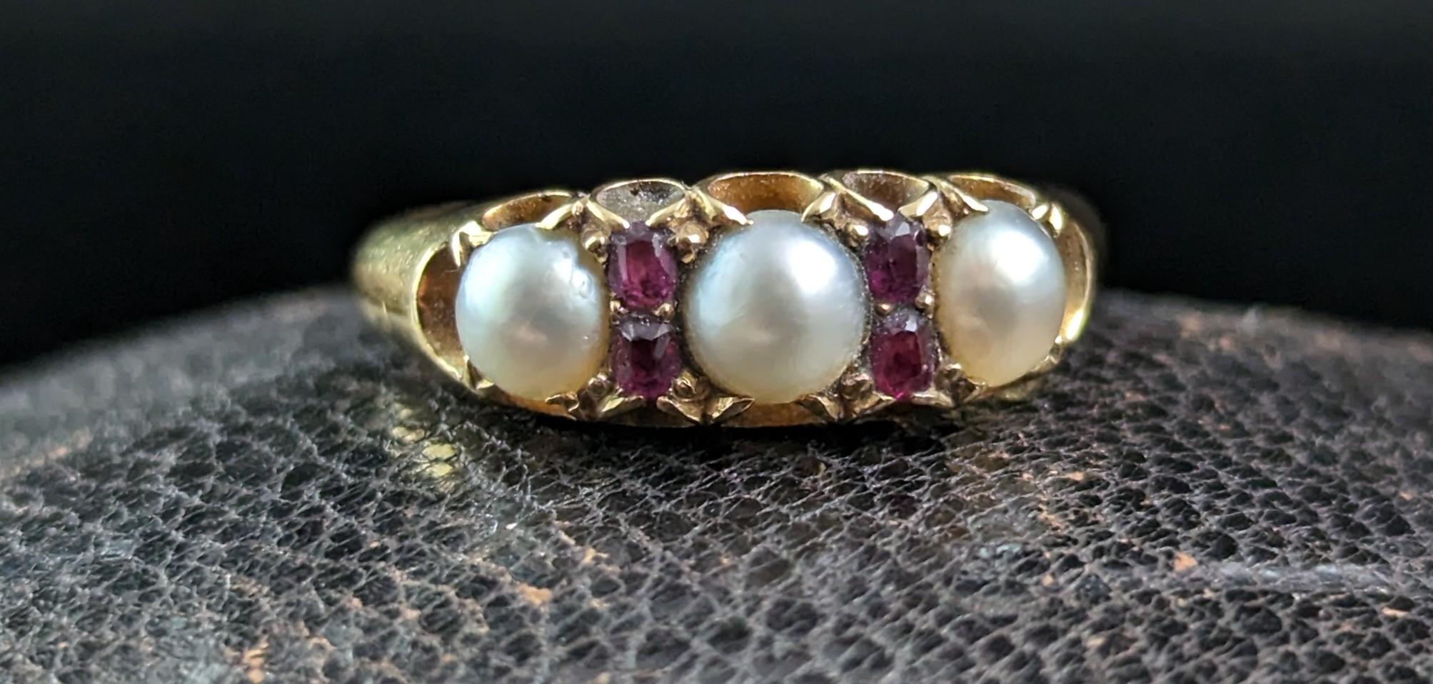 Dieser antike Ring mit Rubin und Splitperle ist einfach göttlich.

Die kühlen, cremefarbenen Perlen bilden einen schönen Kontrast zu den tiefrosa roten Rubinen und dem satten, butterweichen Gold.

Er besteht aus drei cremefarbenen, gespaltenen