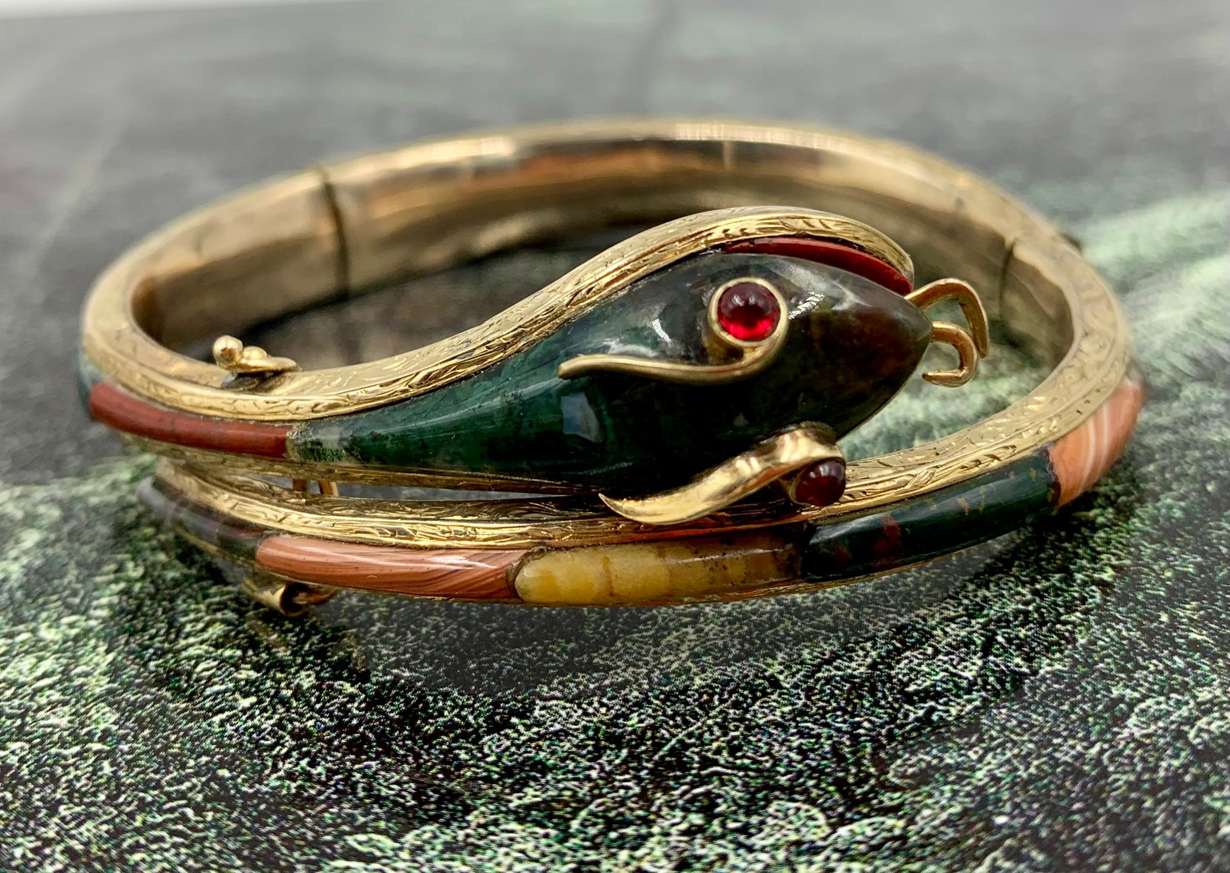 Fine antique ruby, bloodstone, carnelian, agate 14K yellow gold snake bracelet
19th Century
This exquisite snake bracelet features scales of striking, exotic agates- moss, banded, blue lace together with carnelian, red jasper and bloodstone, set in