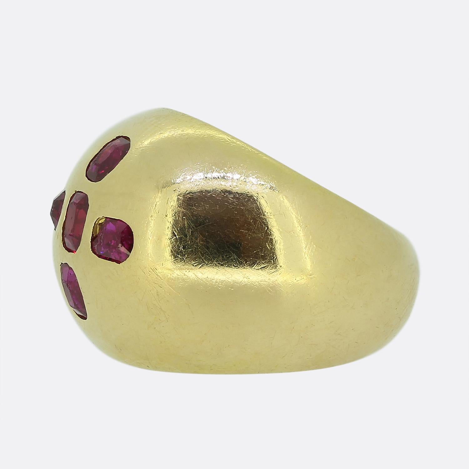 Here we have a striking bombe ring crafted from a warm 18ct yellow gold. At the centre of this dome shaped head we find five oval-faceted rubies, each displaying a perfectly matched rich red hue. Each ruby has been individually rub-over set in a