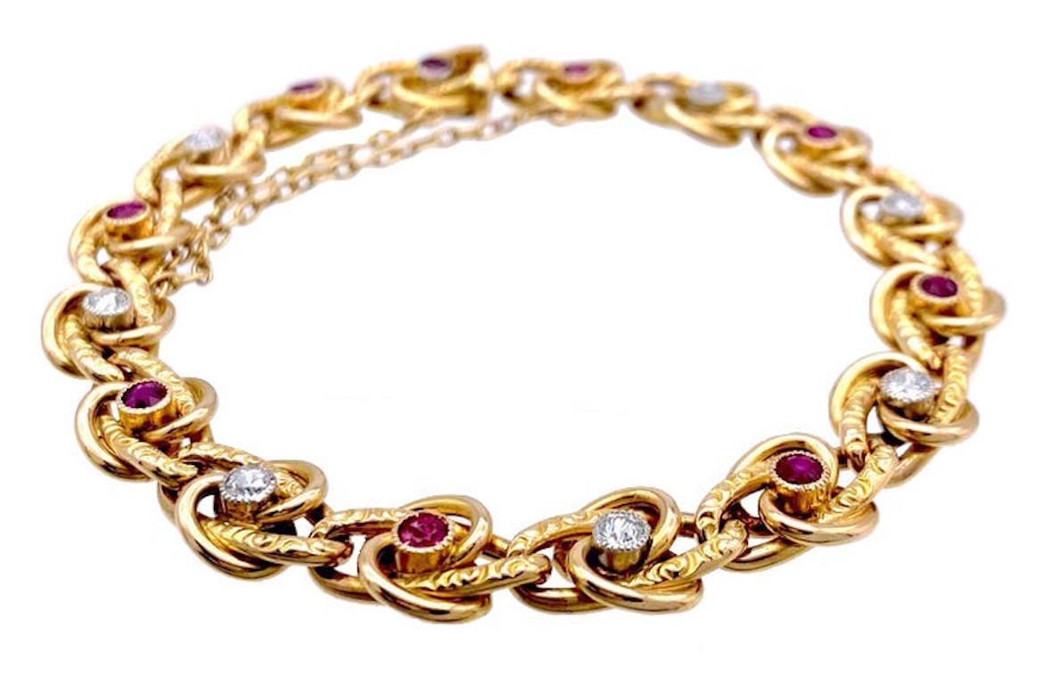 This elegant link bracelet has been beautifully crafted in France in the 1880's out of 18 kt gold and platinum. The links are designed as eternity knots, each knot is set with a round cut precious stone. Nine links are set with rubies, one ruby set