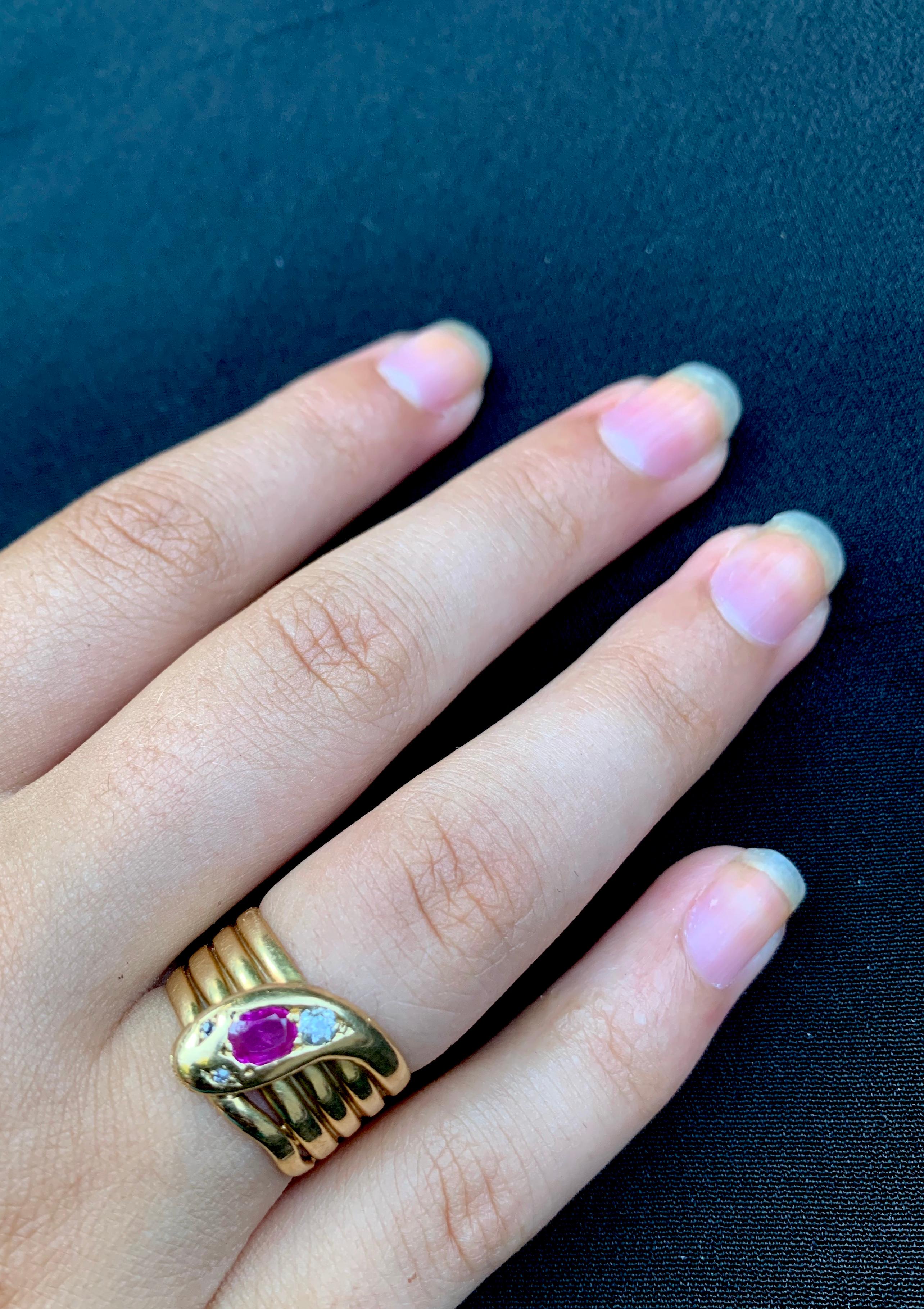 Striking, large antique Edwardian diamond, ruby and 18K yellow gold coiled snake ring
Early 20th Century
The sinuous snake coiled in five circles creating an impactful design, the head set with a beautiful oval ruby, a round European Cut diamond and