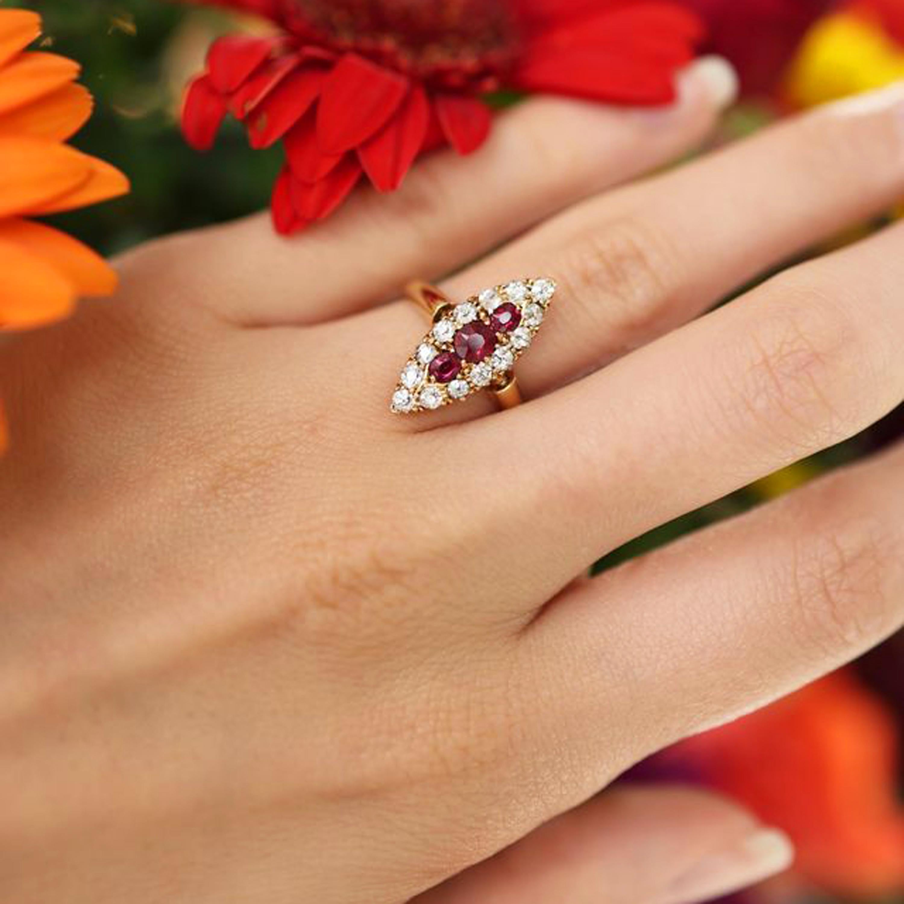 A Victorian ruby, diamond and gold navette shaped cluster ring, with a cushion shaped faceted ruby, in the centre of two oval rubies, surrounded by fourteen old-cut diamonds, in a claw set navette shaped cluster, with a pierced crown gallery, onto a