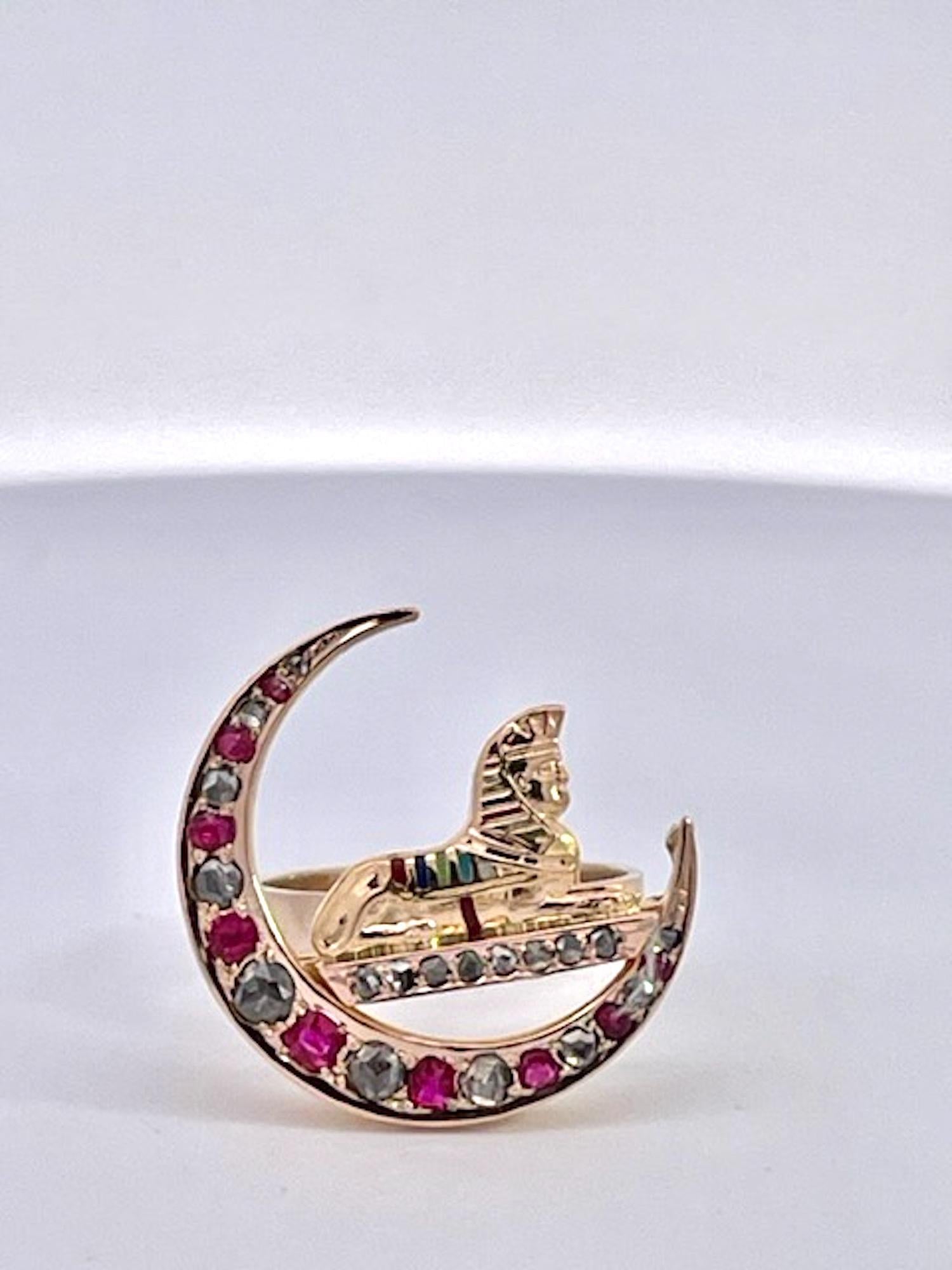 This antique Crescent ring with Enamel Sphinx  is true Egyptian style circa 1900.  This ring is set with Rubies and rose cut Diamonds, with a bit of enamel on the sphinx itself.  This ring is 14K Yellow Gold and weighs in at 4.31 grams.  It measures