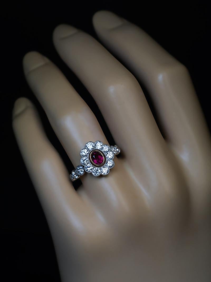 Circa 1910

An Edwardian era finely crafted platinum cluster ring is centered with an oval natural ruby set in a yellow gold bezel. The center stone is framed by bright white old European cut diamonds (F-G color, VS2-SI1 clarity).

The ruby measures