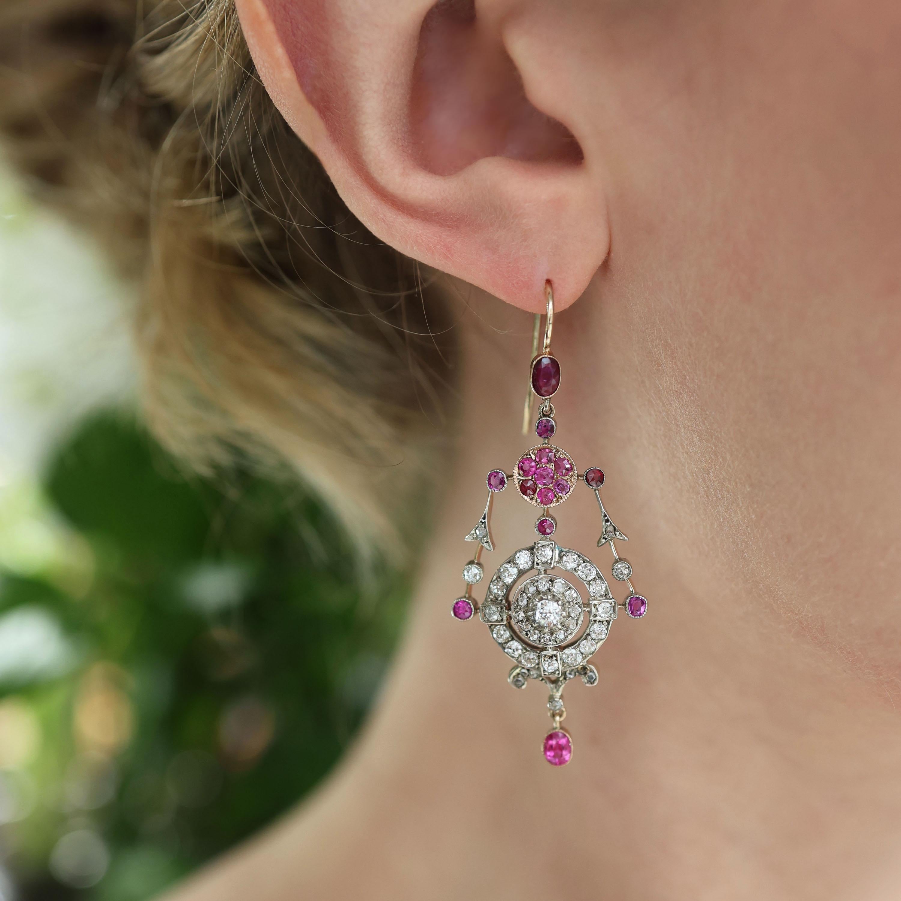 Ein Paar Rubin-, Diamant- und Goldtropfen-Ohrringe, mit Rubinen im Kissenschliff über einem Rubincluster und einem Ring mit Diamanten im Minen- und Rosenschliff darunter, mit einem Cluster in der Mitte, mit Girlanden auf beiden Seiten und einem