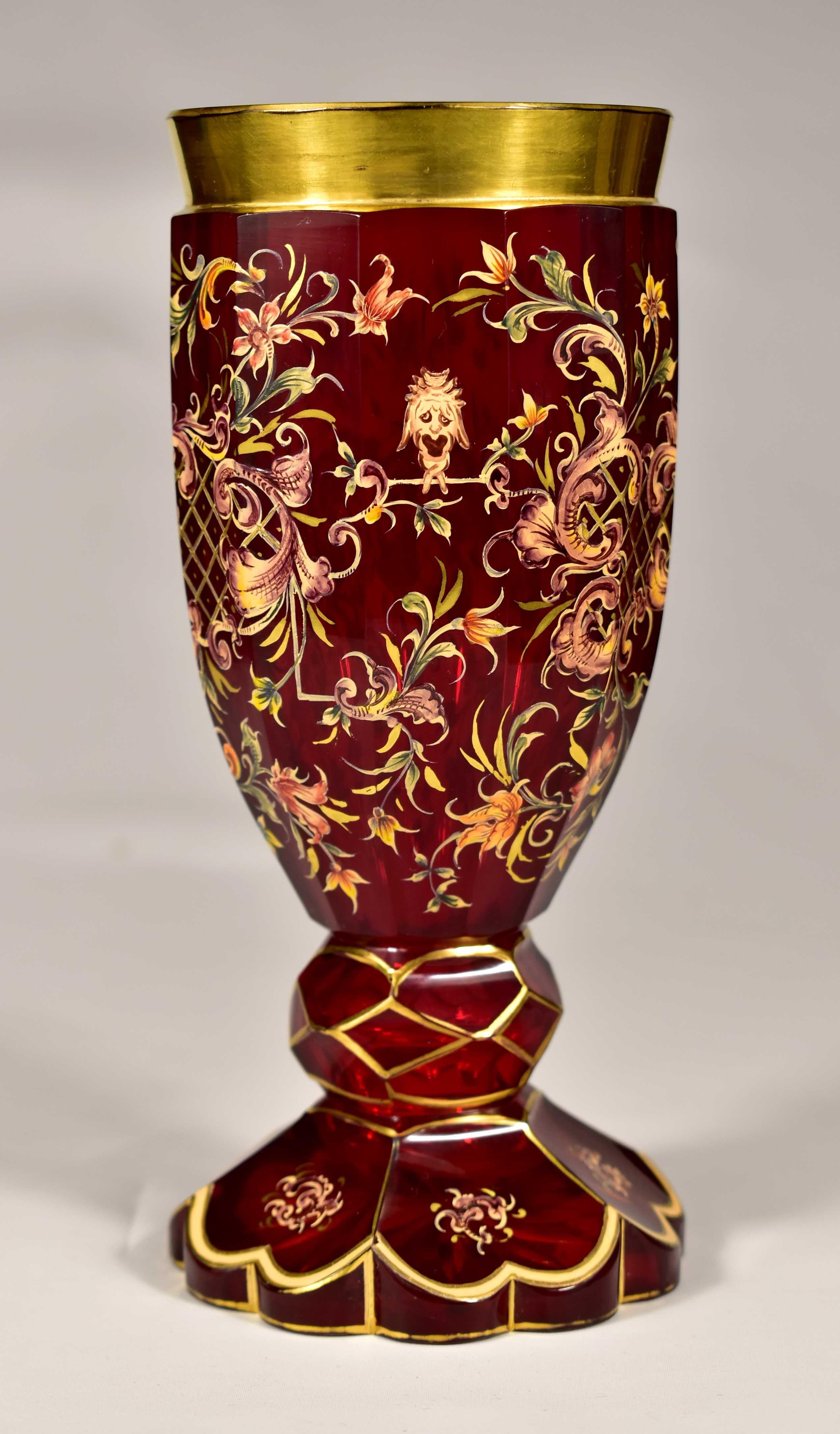 Preciosa copa de rubí tallado , Decorada con pintura ornamental y floral hecha a mano, También hay cabezas de mascarón pintadas, Es obra profesional de maestros vidrieros, probablemente de la primera mitad del siglo XX. La ejecución es igual a la