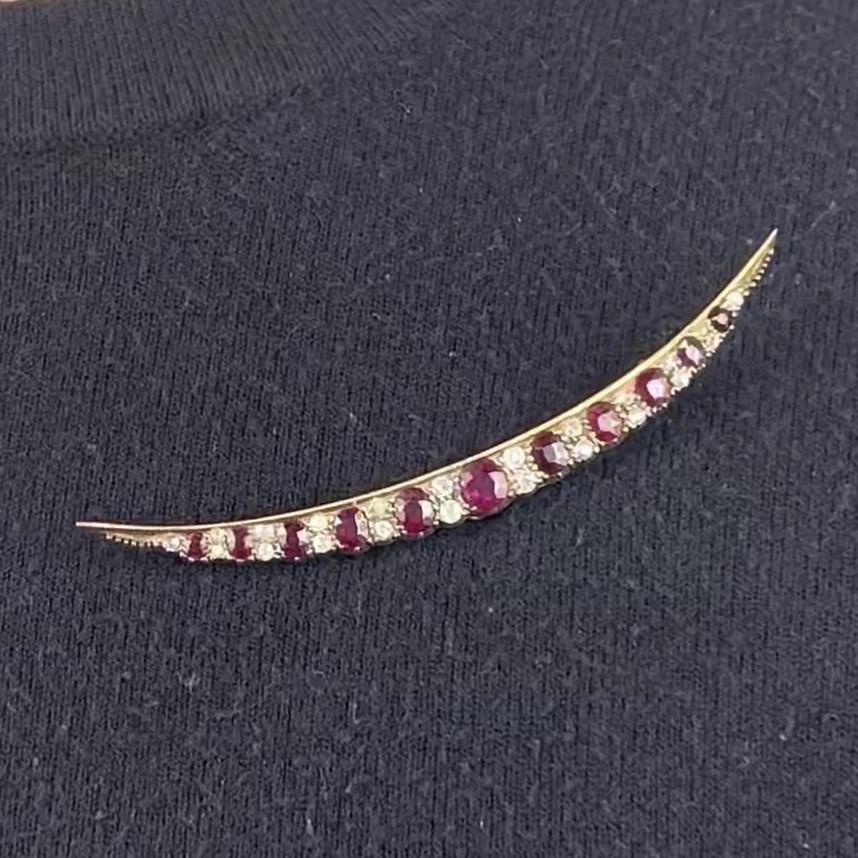 One Antique Ruby Old Cut Diamond Gold Crescent Brooch. Featuring 11 oval shaped rubies with a total weight of approximately 4.00 carats. Accented by 22 round cut diamonds with a total weight of approximately 1.00 carat, graded I-J color, SI-I