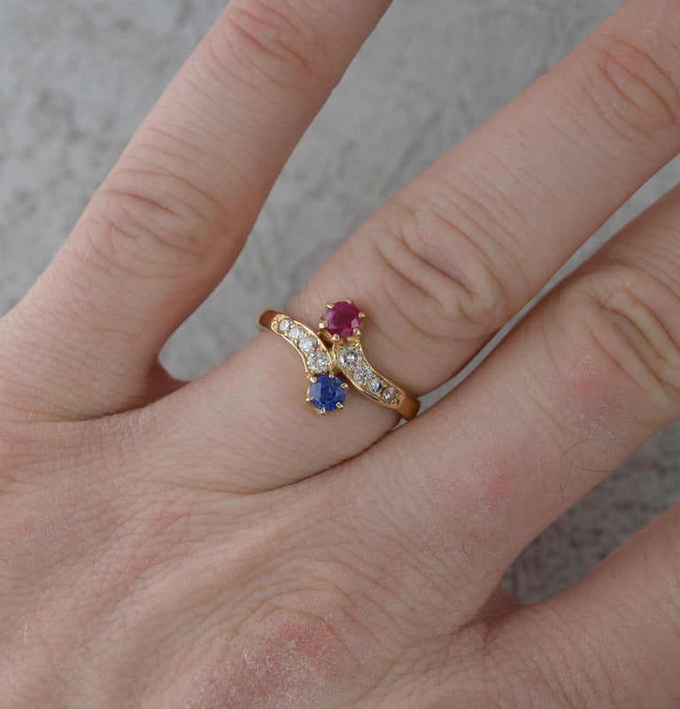A very fine toi et moi ring. Circa 1900.
Solid 18 carat yellow gold.
Designed with a round cut natural sapphire and ruby in multi claw setting with eight natural diamonds to the band.
15mm x 11mm spread of stones.

CONDITION ; Very Good for age.