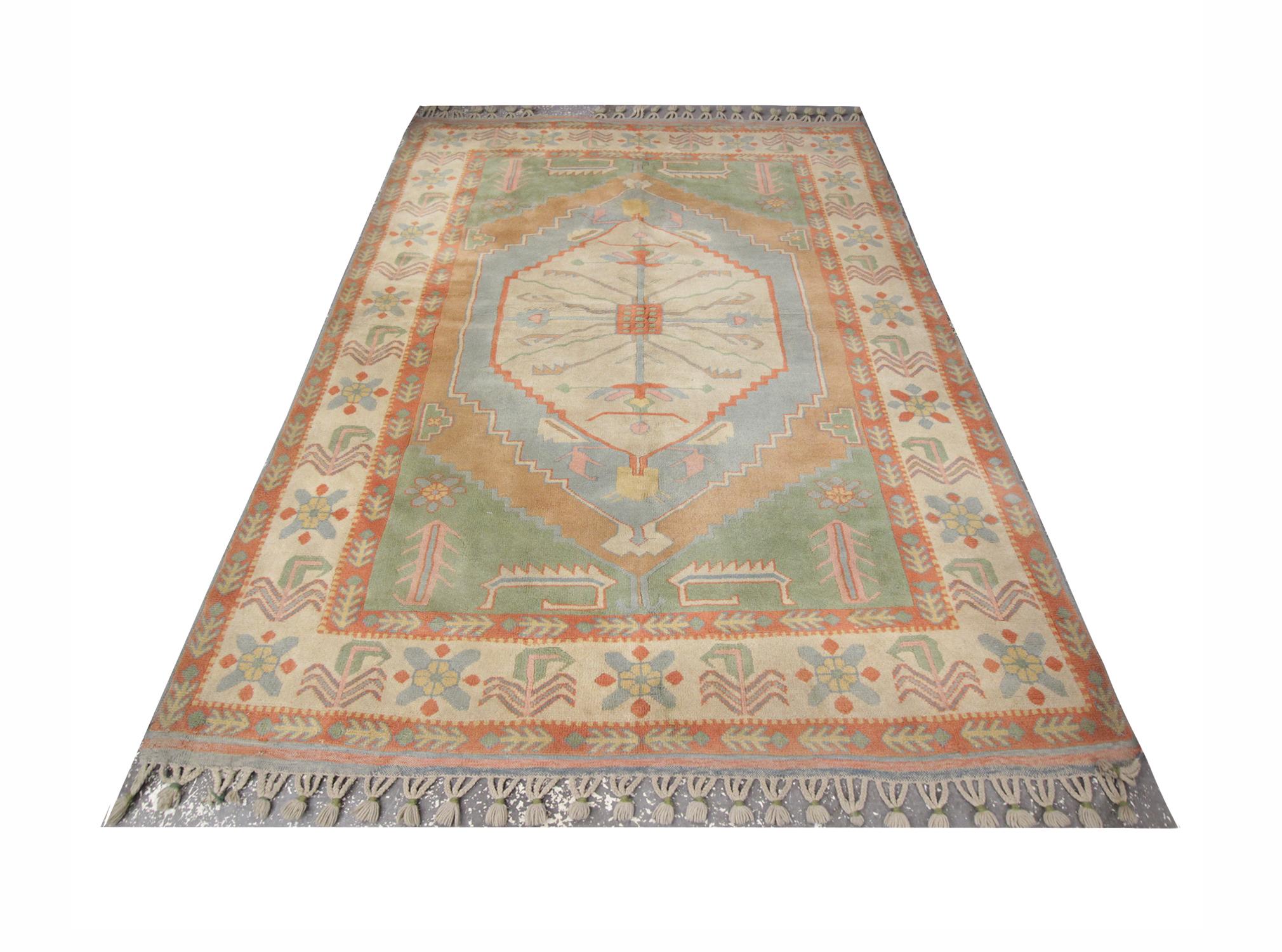 This soft color vintage Milas woven rug rests beautifully upon a field of pale lime green, light grey and brown colors. This geometric rug has a medallion of multi-colors and neutrals takes centre stage and the tribal rug is well balanced by four