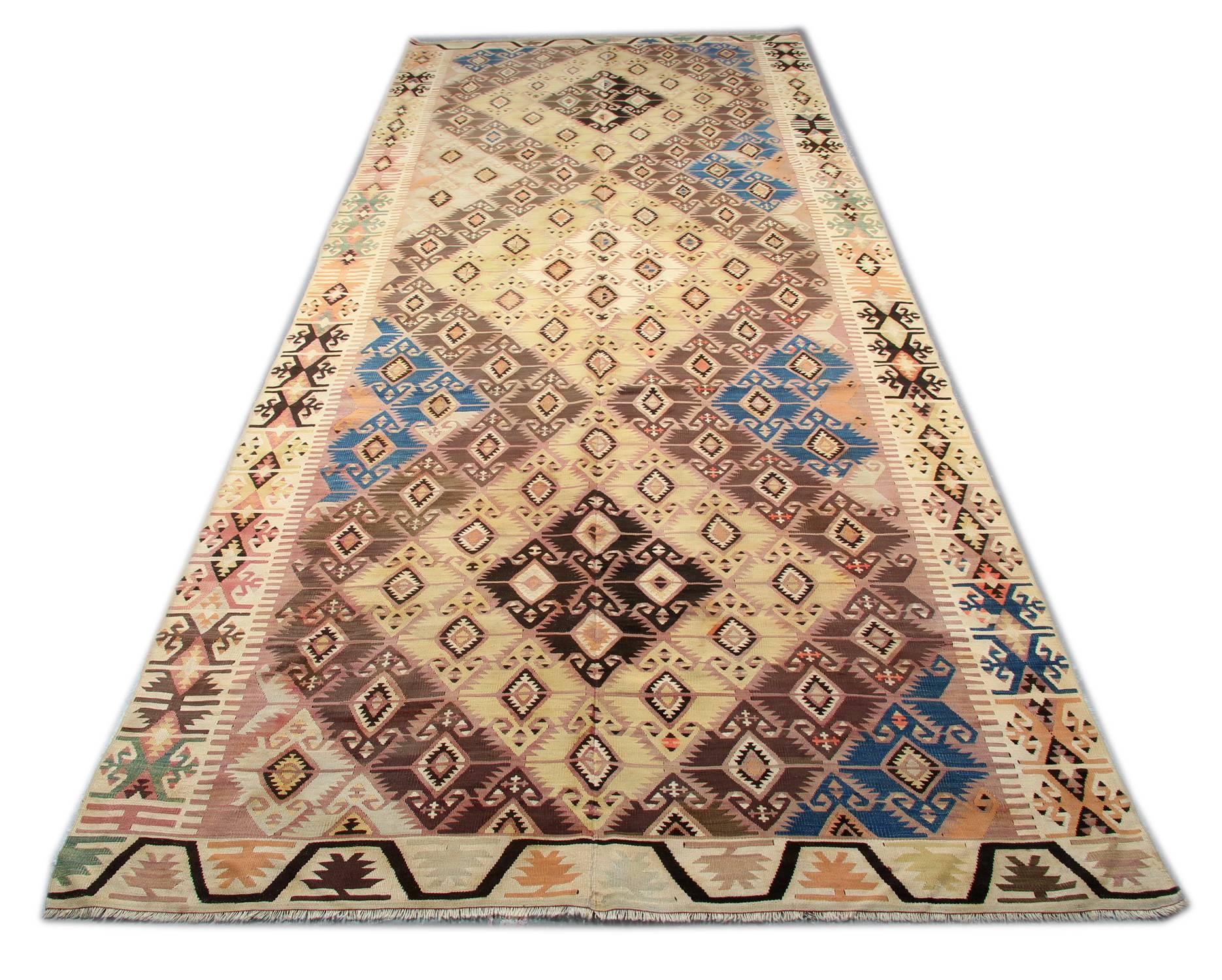 Ce tapis coloré fait à la main est un tapis turc tissé par des tisserands très qualifiés en Turquie, qui ont utilisé de la laine et du coton de la plus haute qualité. Le tapis à tissage plat présente des couleurs orange clair, orange, vert, blanc,