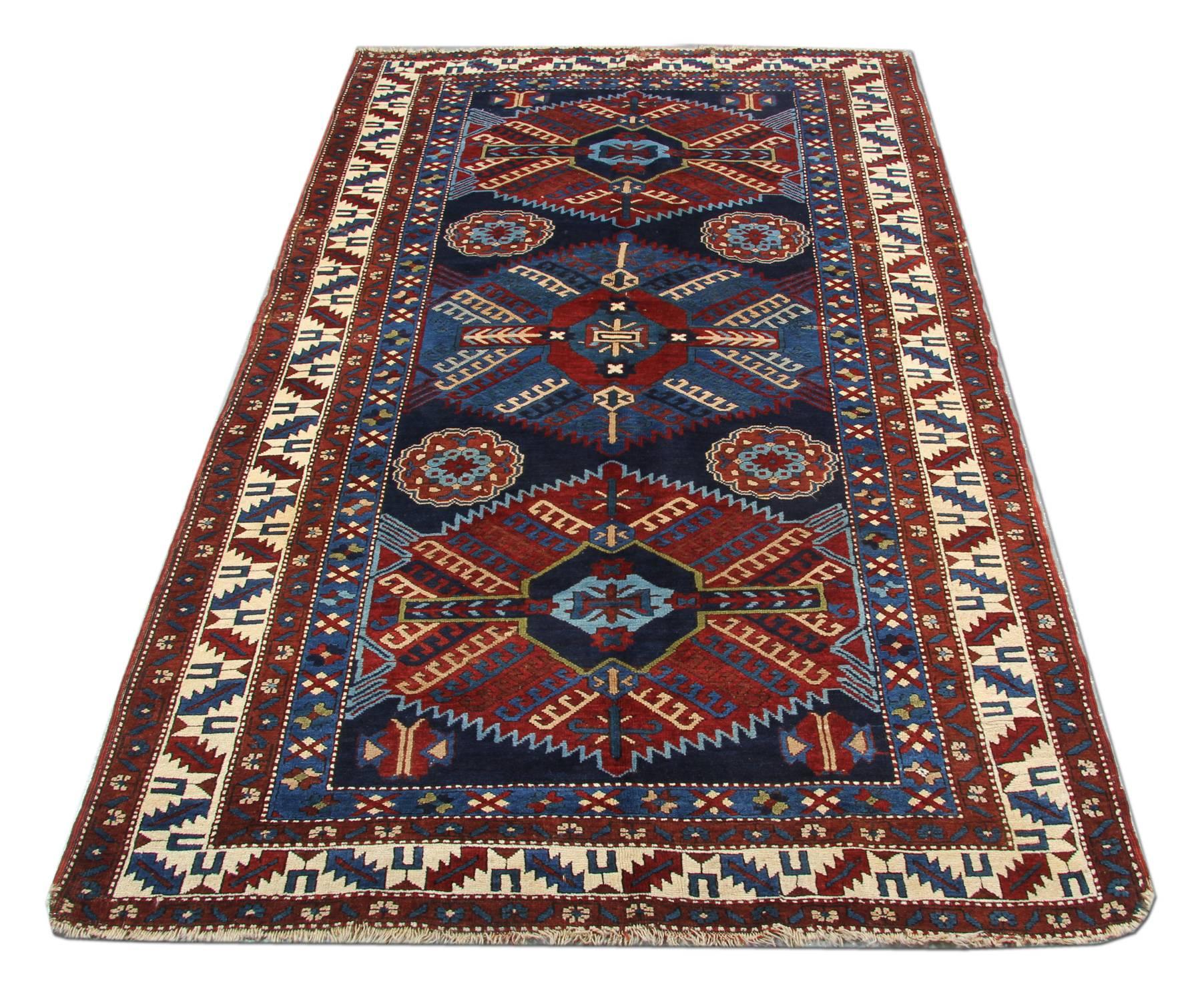 An excellent handwoven Kazak rug example of Caucasian handmade carpet rug weaving from the Kazak region. Though this dark blue rug has a Shiny background and 3 stylish Central Medallion patterned rugs may seem like from a distance, but this woven