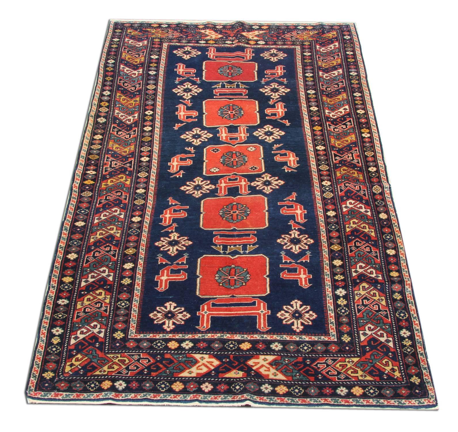 This handmade carpet handsome antique Caucasian rug is a phenomenal and truly archetypal example of regional oriental rugs from the Azerbaijani village of Karakashly. This local variant of the Afshan pattern features crimson calyces with right-angle