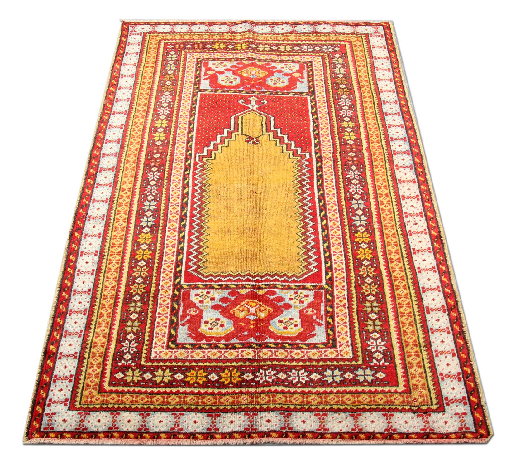 This handmade carpet soft colour vintage rug Milas carpet rests beautifully upon a field of shiny yellow rug, red, and blue colours. A relatively broad border of red and blue gently surrounds the centre field. Natural elements of stems, vines and
