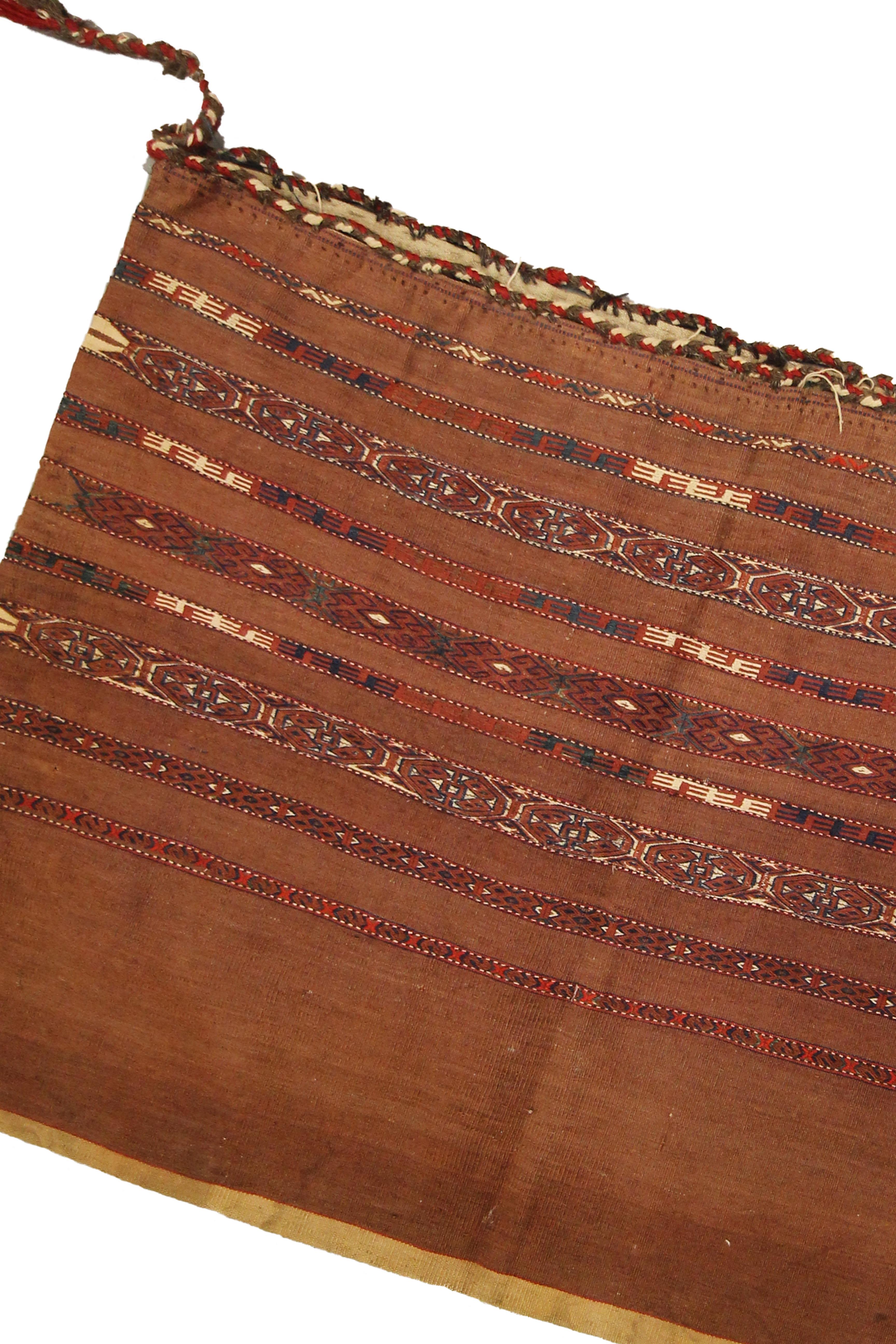 This fine wool textile is a fantastic example of handwoven rugs from the early 20th century, circa 1900. The design is simple with a rust background and a stripe geometric pattern woven in accents of blue, brown and cream. Both the colour and design