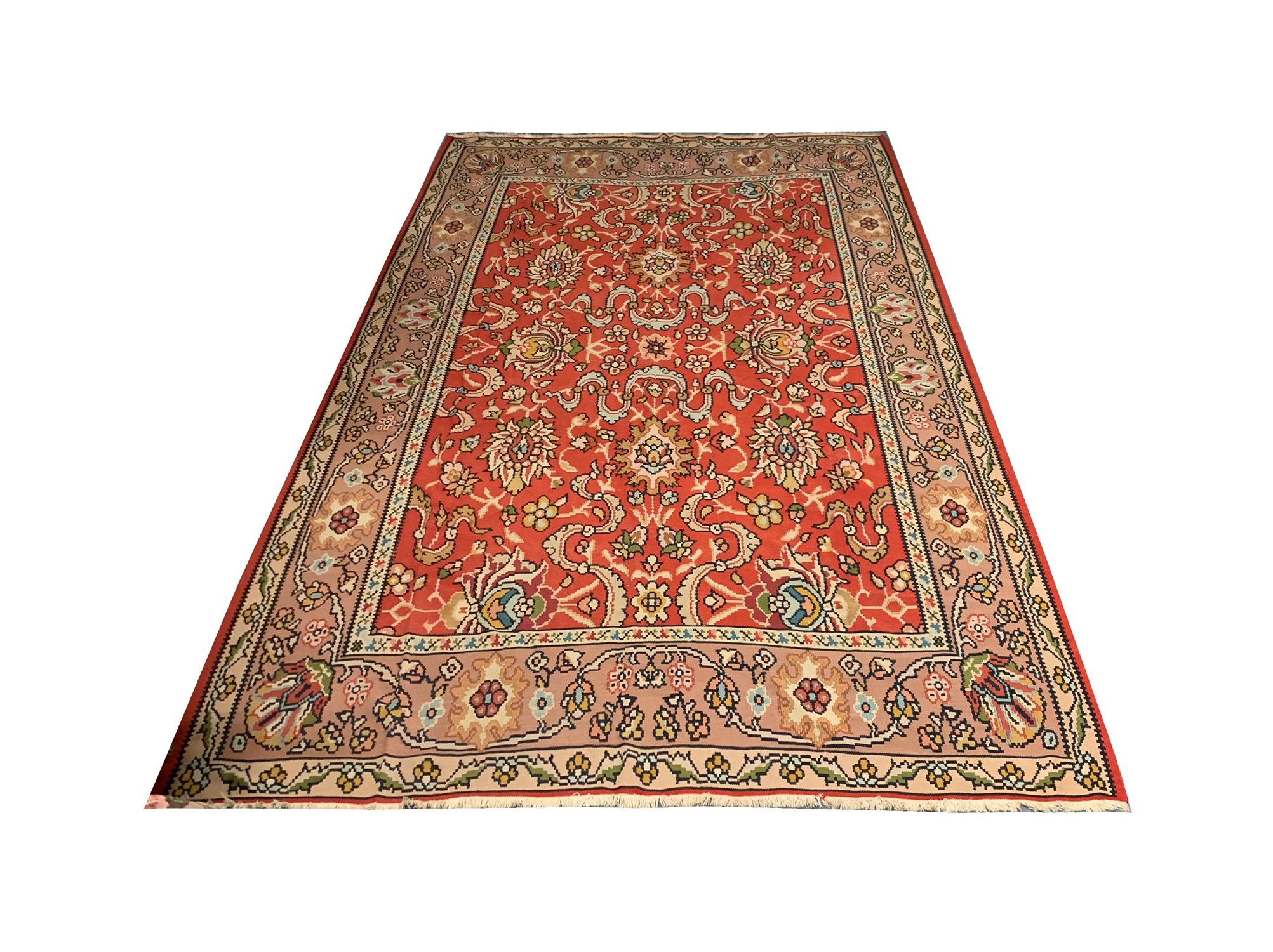 Dieser antike Teppich aus feiner roter Wolle wurde in den 1930er Jahren in der Türkei, Anatolien, von Hand gewebt. Das zentrale Muster besteht aus einem symmetrischen All-Over-Muster, das mit floralen Mustern gewebt ist. Aufwändig gestaltet und aus