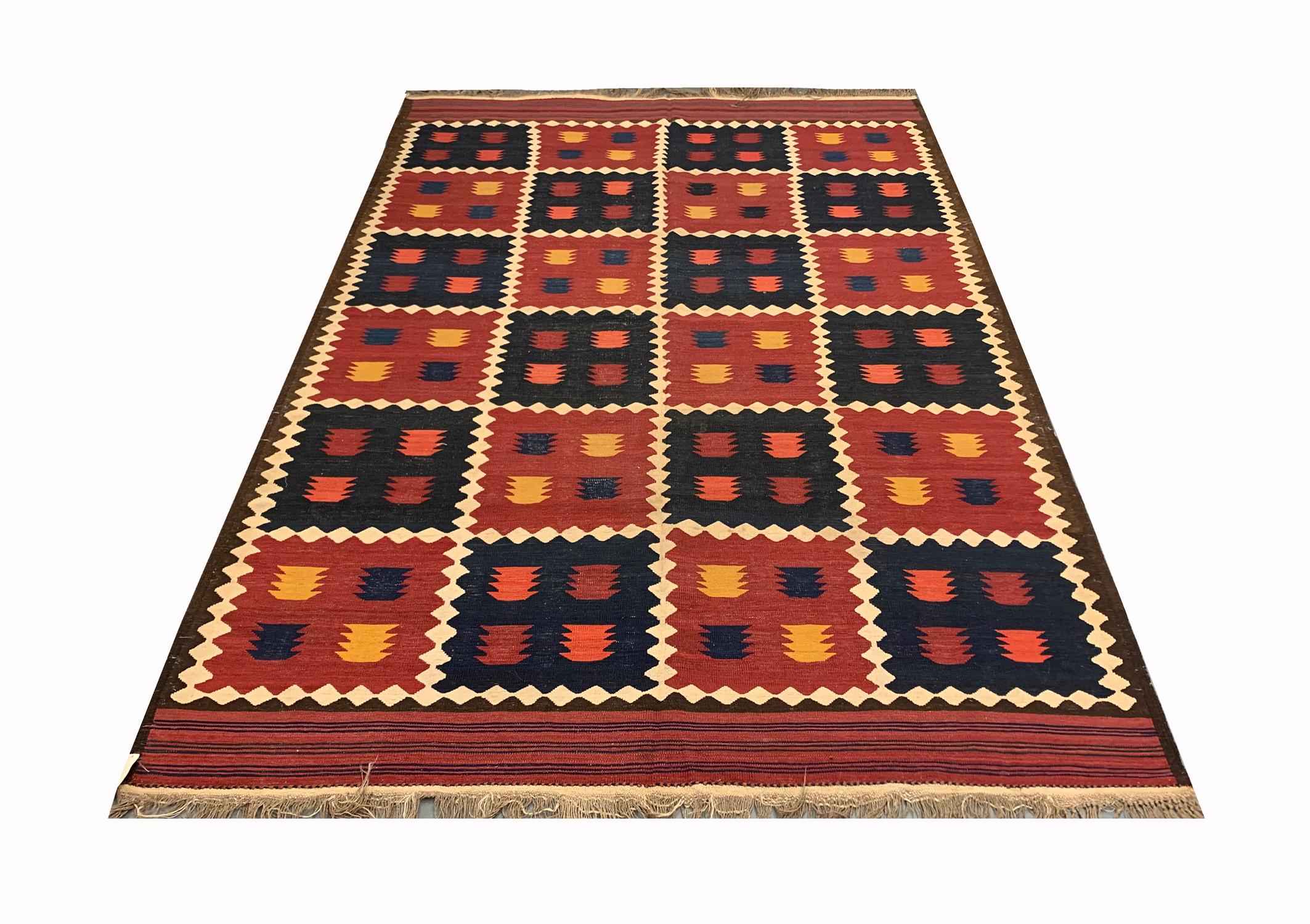 An antique masterpiece, this fine wool Kilim was woven in the late 19th century Circa 1890. The design reveals a bold pattern with a square repeating pattern in deep blue and red colours, and motifs are woven in mustard blue and red. This is then