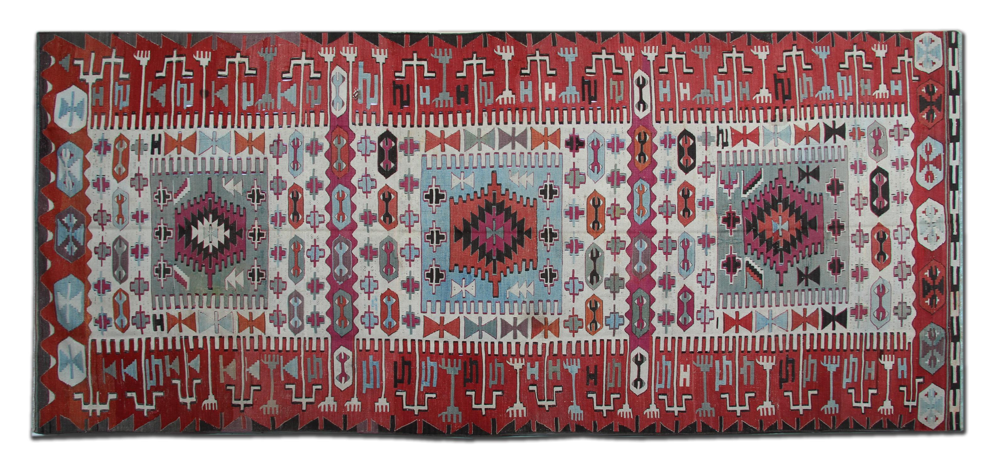 Esta alfombra antigua de lana fina se tejió a mano en Turquía en 1890 con materiales orgánicos finos. El diseño central presenta tres grandes medallones tejidos en colores marfil, azul y verde de acento, un rico borde rojo con detalles en marfil