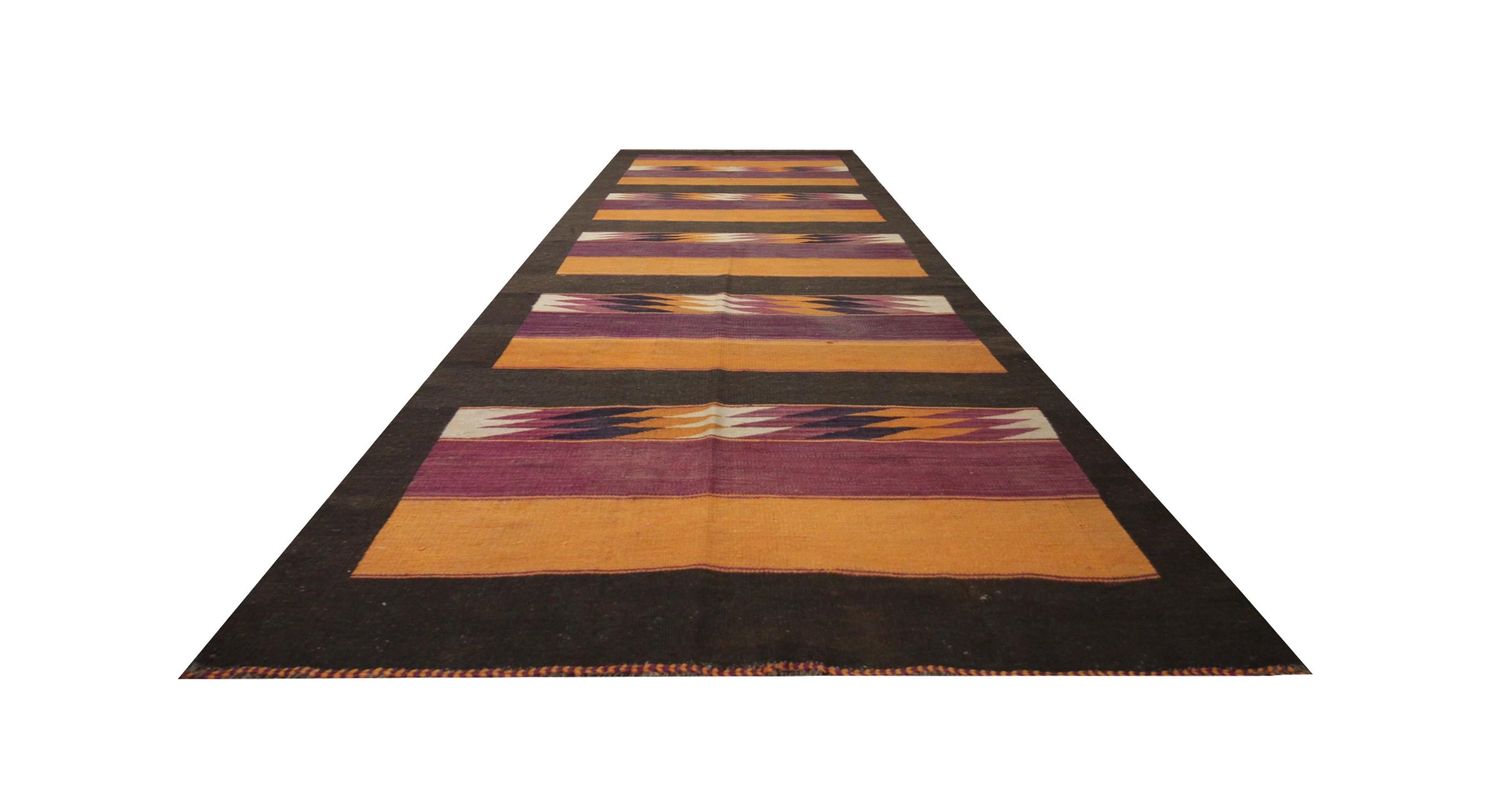 This kilim rug was woven by hand in the 1960s/70s with a simple stripe design and intertwined with purple, orange and brown accents in a repeating pattern. The colour palette and design make it easily matchable to both classic and contemporary home