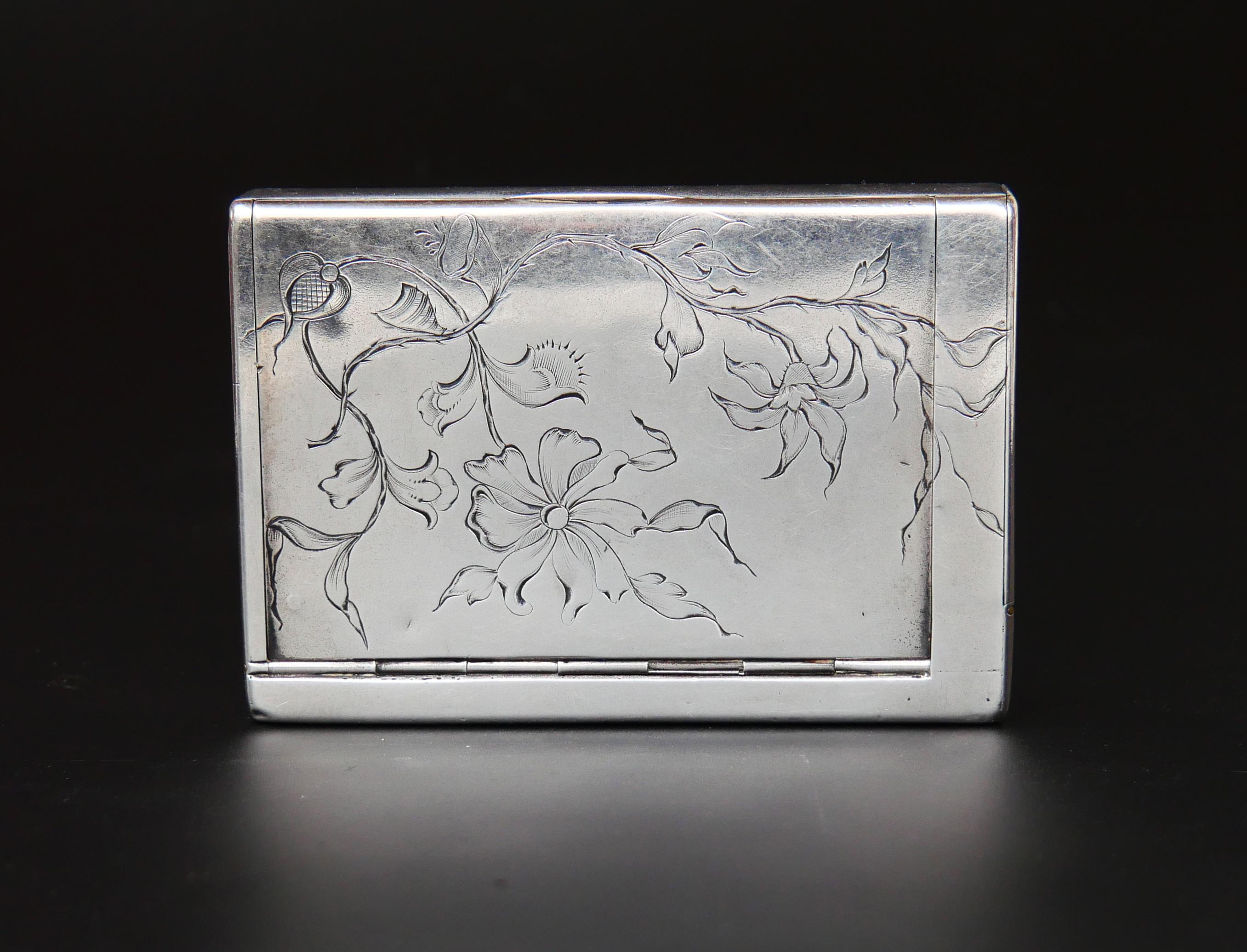 Russian cigarette case box in solid 84 Silver with intricate hand-engraved floral decor on the lid and gilt interior. Hidden compartment for matches on one side with removable match-striking paper on top of a hinged lid.

Hand-made in Moscow between
