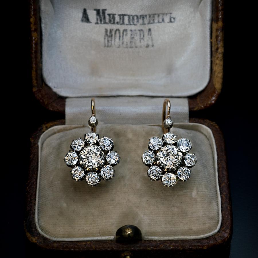 This pair of antique 14K gold and silver cluster earrings was made in Moscow in the 1880s - early 1890s.

The earrings are set with sparkling bright white old European cut and old mine cut diamonds (G-H-I color, VS-SI clarity). The center stones are