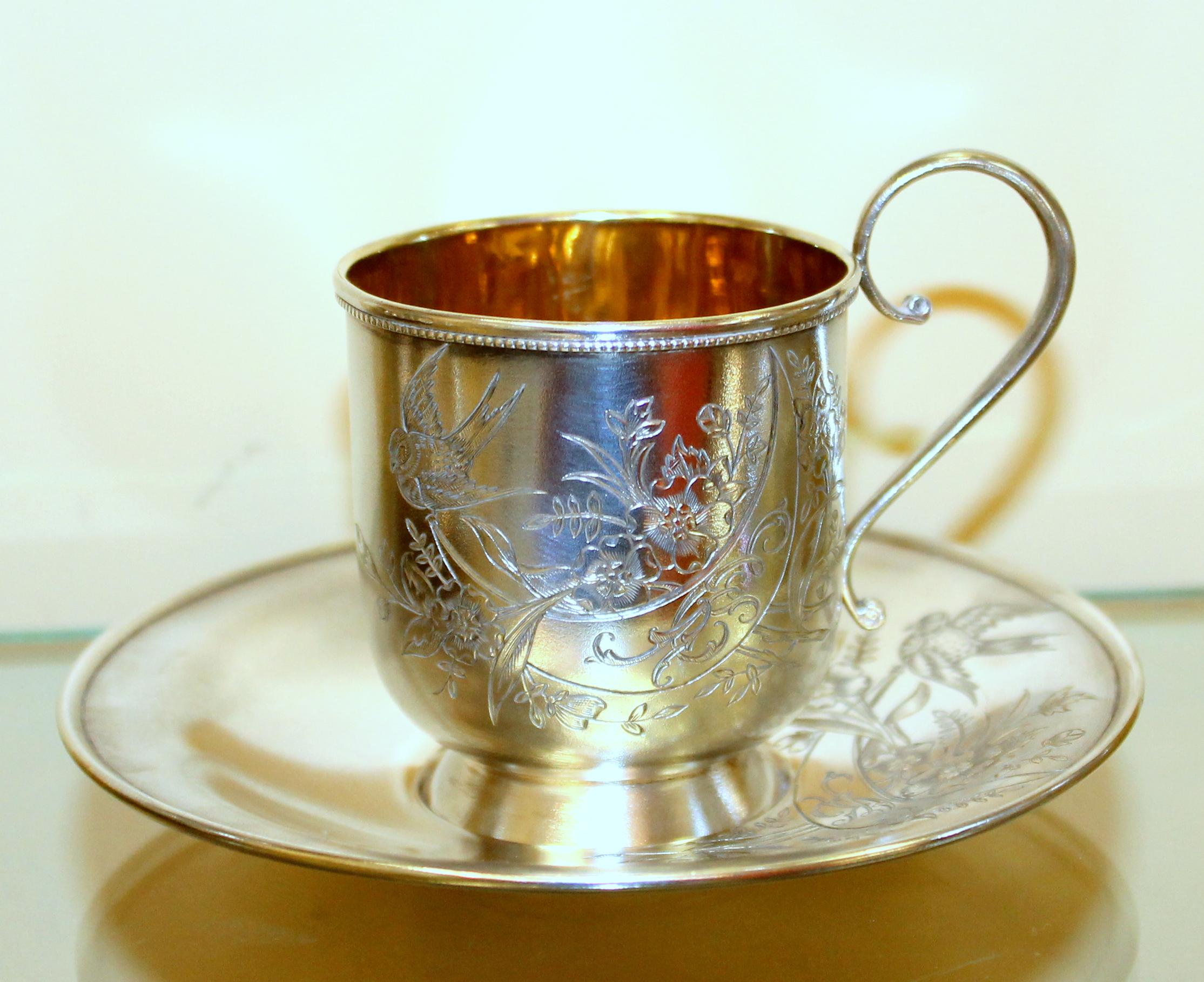 Exceptionally fine and rare antique Russian .875 fine silver hand engraved cup and saucer against a 