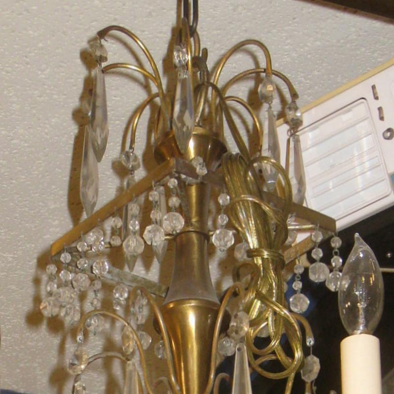Petite Russian Baltic style chandelier with glass stem and gilt metal frame, numerous faceted crystal pendants and four electrified candle arms.