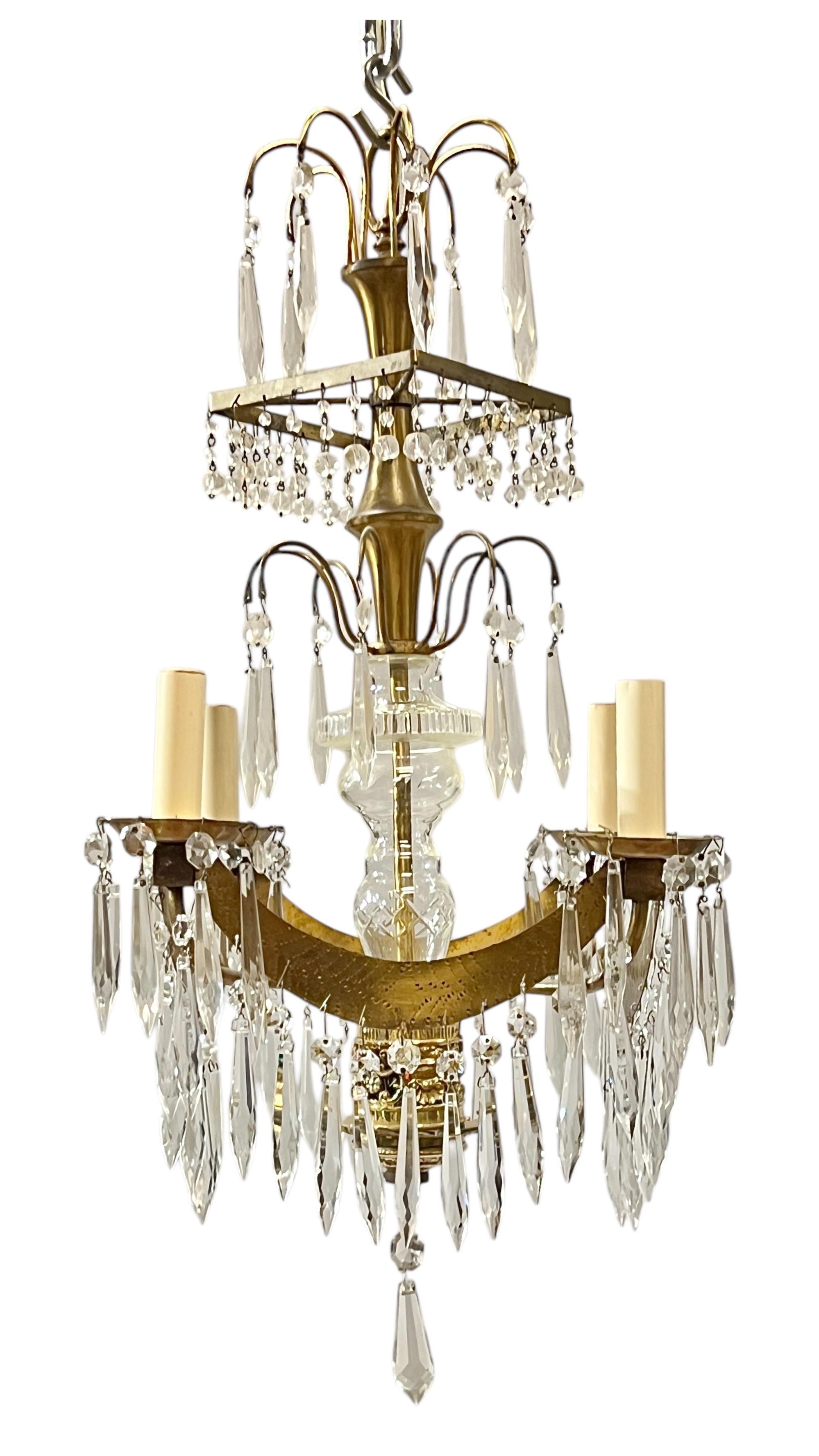 Petite Russian Baltic style chandelier with glass stem and gilt metal frame, numerous faceted crystal pendants and four electrified candle arms.