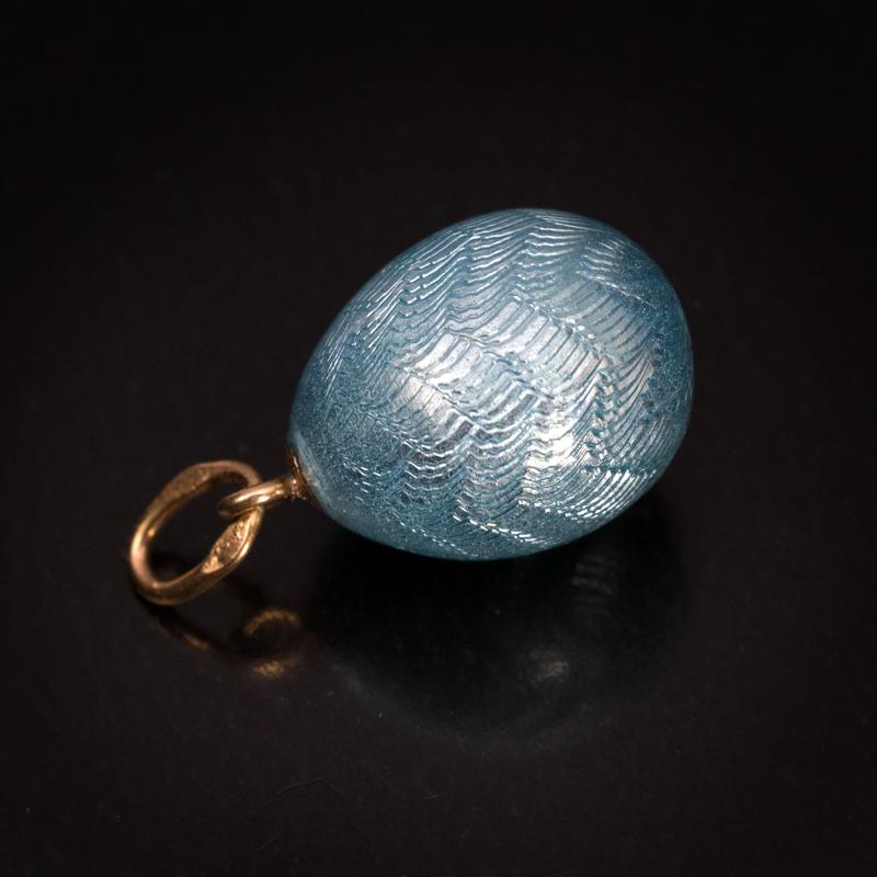 Made between 1908 and 1917.

This FABERGE miniature egg with a wavy moiré pattern is covered with an aquamarine blue translucent enamel of a very fine quality.

The egg is marked with 56 zolotnik old Russian gold standard and initials ‘ФА’ for